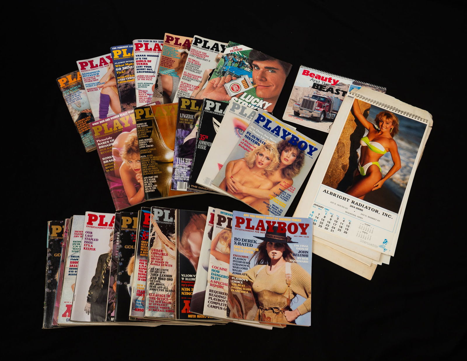 LARGE GROUP OF PLAYBOY MAGAZINES AND SWIMSUIT ADVERTISING CALENDARS.: 1980s Playboy magazines and ten 1990s swimsuit calendars.Provenance: From the Lifetime Collection of Chuck Auerbach. Box 9"h. 20". 16"d.