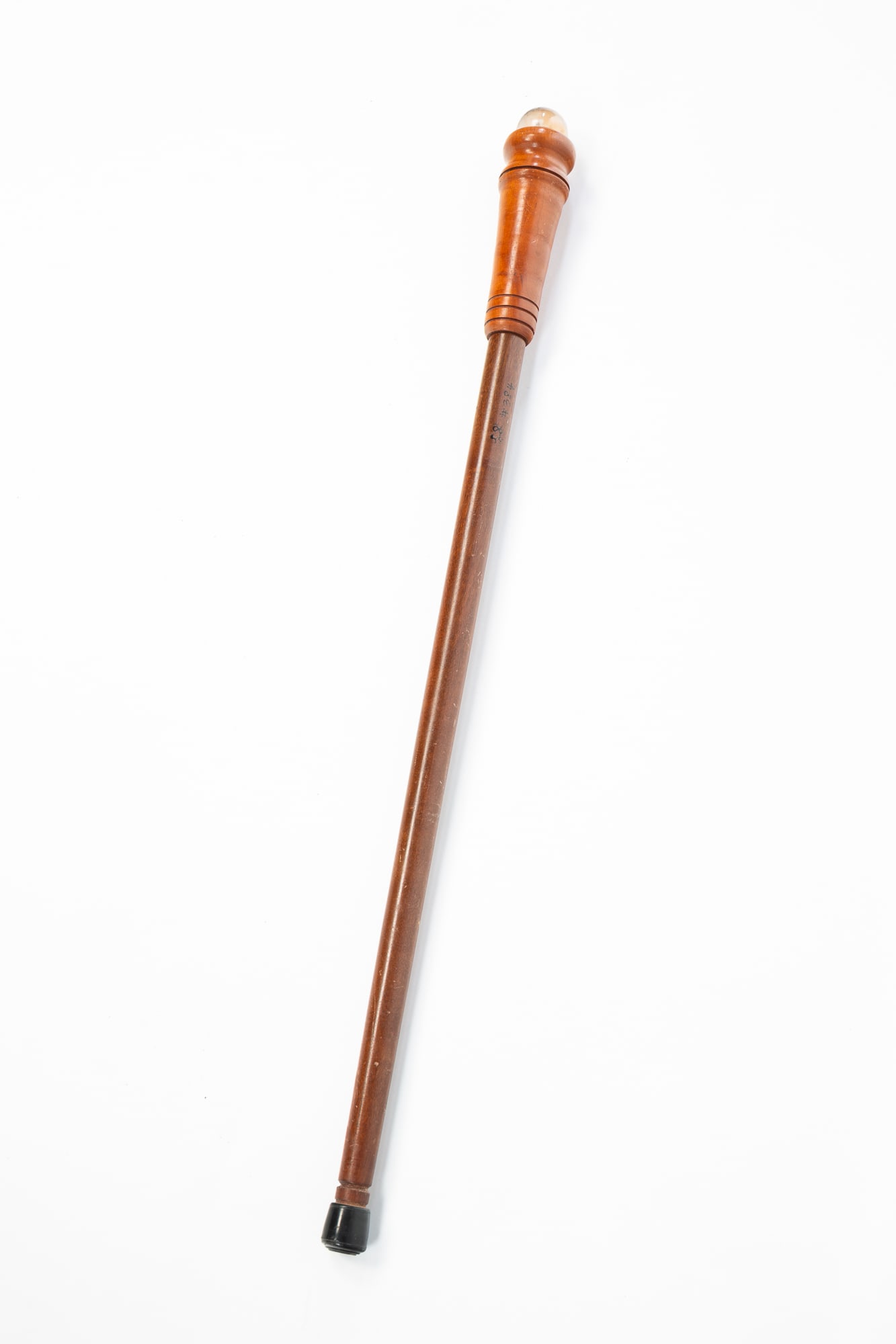 WALNUT AND CHERRY WALKING STICK WITH SQUIRREL SULFIDE MARBLE TOPPER.: Ca. 1900 and later. A straight stick with a flame finial form top holding a clear glass squirrel sulfide. 35.5"h. 2.5"w.