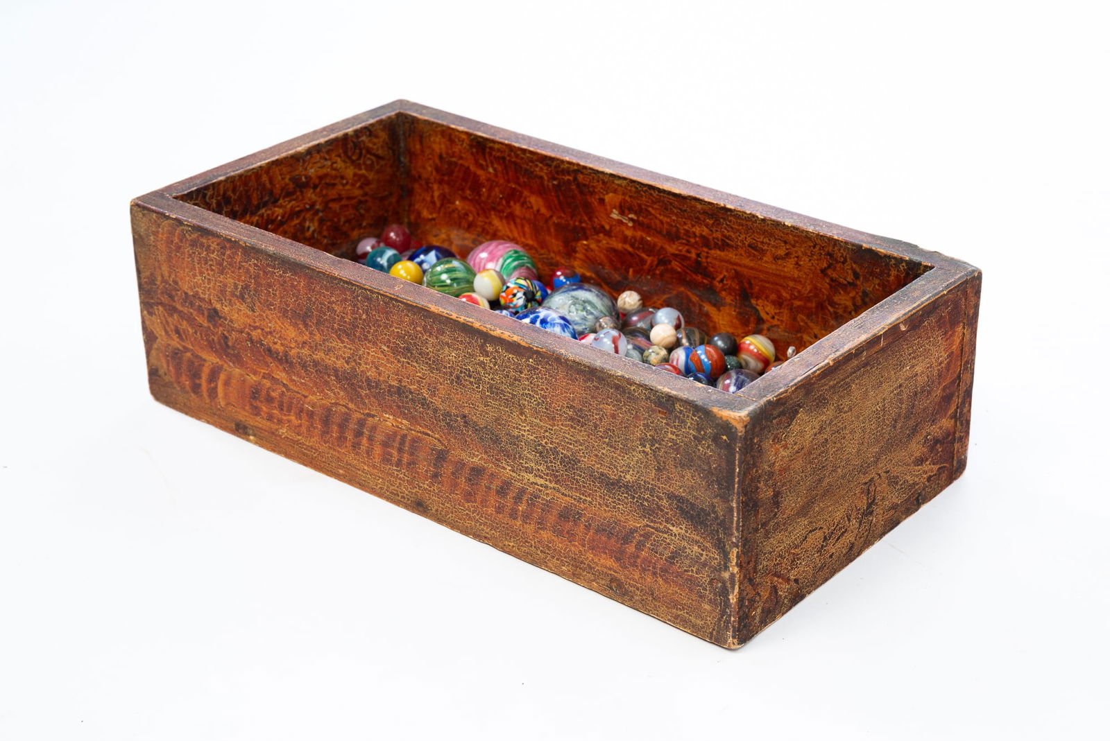 LARGE COLLECTION OF HAND-BLOWN GLASS MARBLES IN VINEGAR GRAIN-PAINTED WOODEN BOX.: American and German, 19th-20th Century. Mostly all hand-blown glass with swirls, including some onion-skin. Varying colors and ranging in size from 1.5"d. to 0.5"d. All housed in a 19th-century vinega