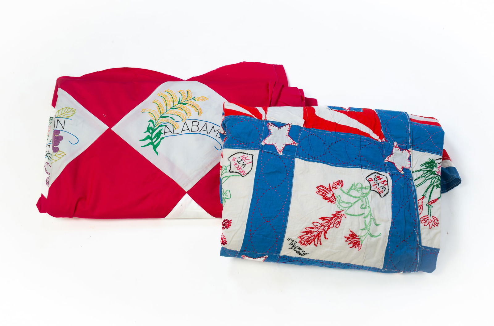 TWO AMERICAN COTTON STATE FLOWER QUILT TOPS: Second half 20th Century. One has blue, white, and red solid-colored fabrics and embroidered blocks with state flowers, type of flower, state and admission date into the union. Blue grid with stars an