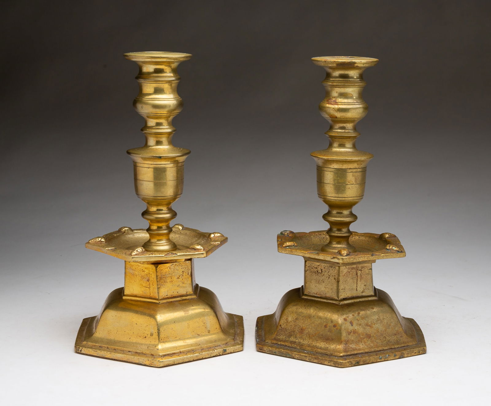 PAIR OF SCANDINAVIAN BAROQUE-STYLE FIGURAL MASK BRASS CANDLESTICKS. Each, 11"h. 7.25"w. 7.25"d. (1 of 3)