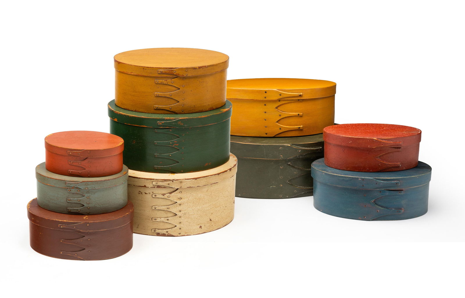 STACK OF TEN SHAKER STYLE PAINTED BENTWOOD AND FINGER-LAPPED BOXES, INCL. FOUR MARTY TRAVIS: All having an oval lid above a conforming body and copper tacks. The Marty Travis boxes painted in red, blue, yellow, and green, respectively. The undersides of the lids are signed "Marty Travis / 199