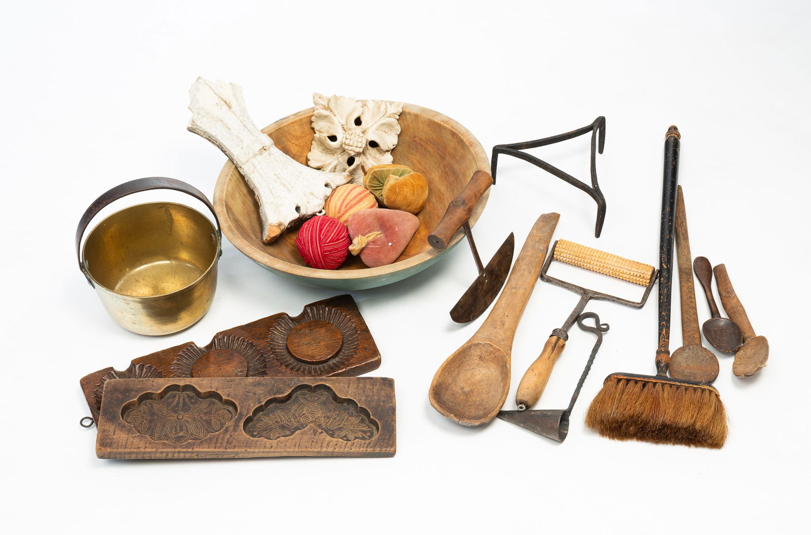ECLECTIC GROUP OF AMERICANA, INCL. TIGER MAPLE SUGAR MOLD. Largest, 3.75"h. 13"d.: 19th-20th Century. A pine treen bowl with newer light blue paint. A cast brass jelly kettle with iron handle. Two carved architectural items with layered white paint, a long-handled brush with acorn f