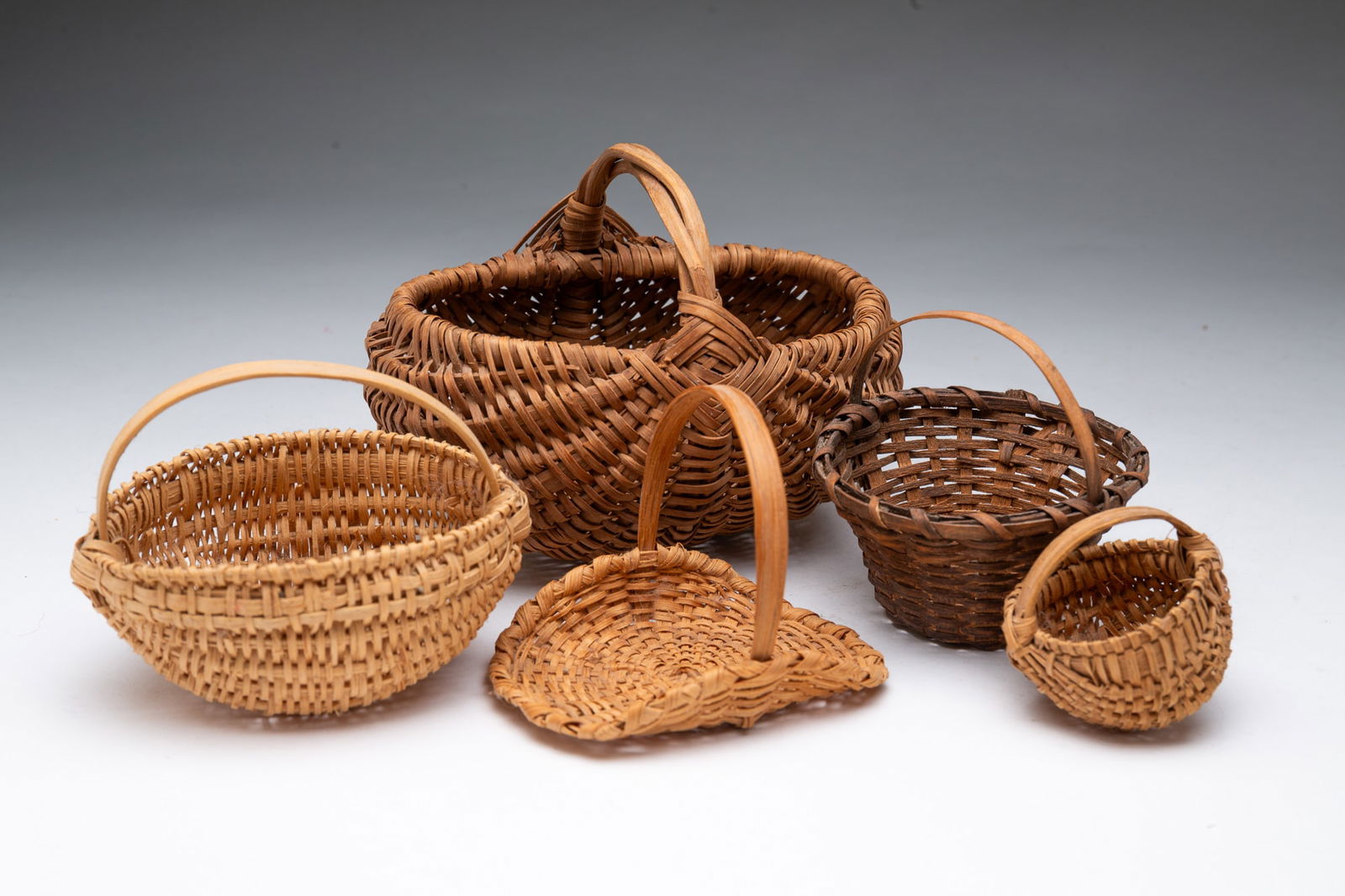 FIVE AMERICAN SPLINT-WOVEN MINIATURE BASKETS WITH HANDLES. Buttocks basket with God's eye, 5"h. (1 of 4)