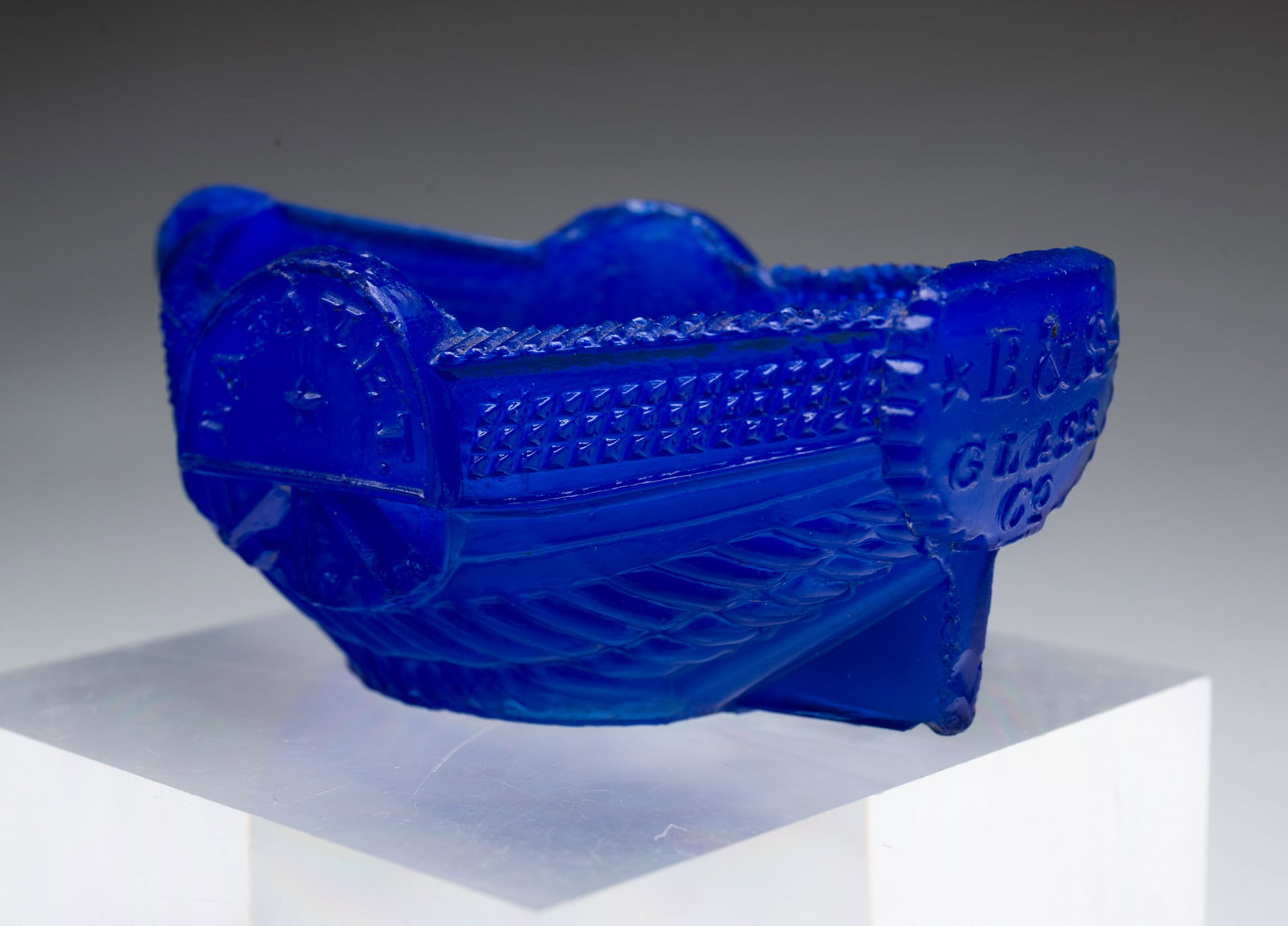 BOSTON AND SANDWICH GLASS CO. "LAFAYETTE" MASTER SALT. 1.5"h. 2"w. 3.5"l.: American, Second quarter 19th Century. Opaque dark blue in a sidewheel steamboat form. "LAFAYETTE" lettered on wheelhouses, "SANDWICH" across inside bottom, and "B&S GLASS Co."across stern transom.SHI