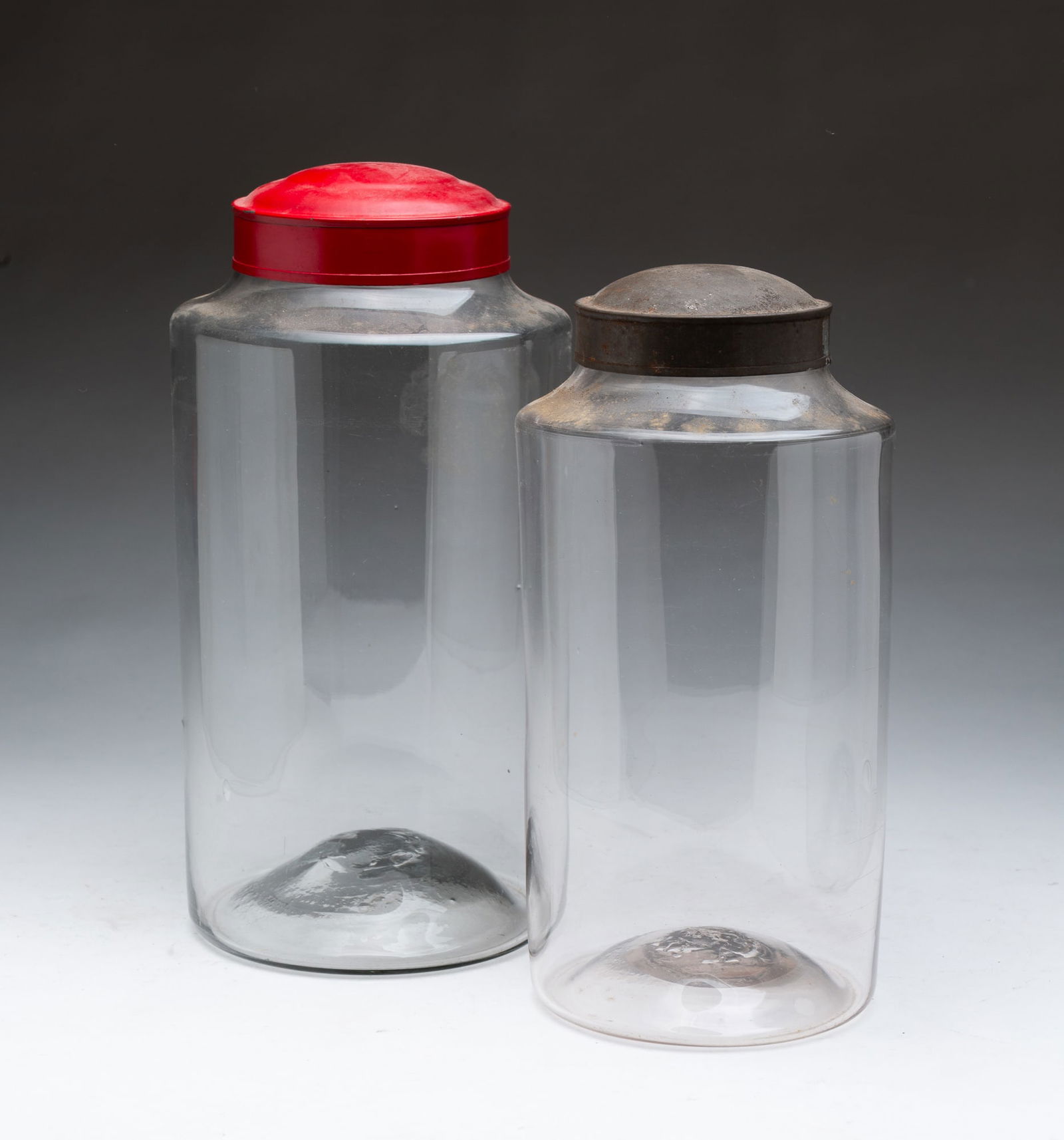 TWO AMERICAN BLOWN CLEAR GLASS CANISTER JARS. 11.5"h. 5.75"d. and 10.25"h. 4.75"d. (1 of 3)