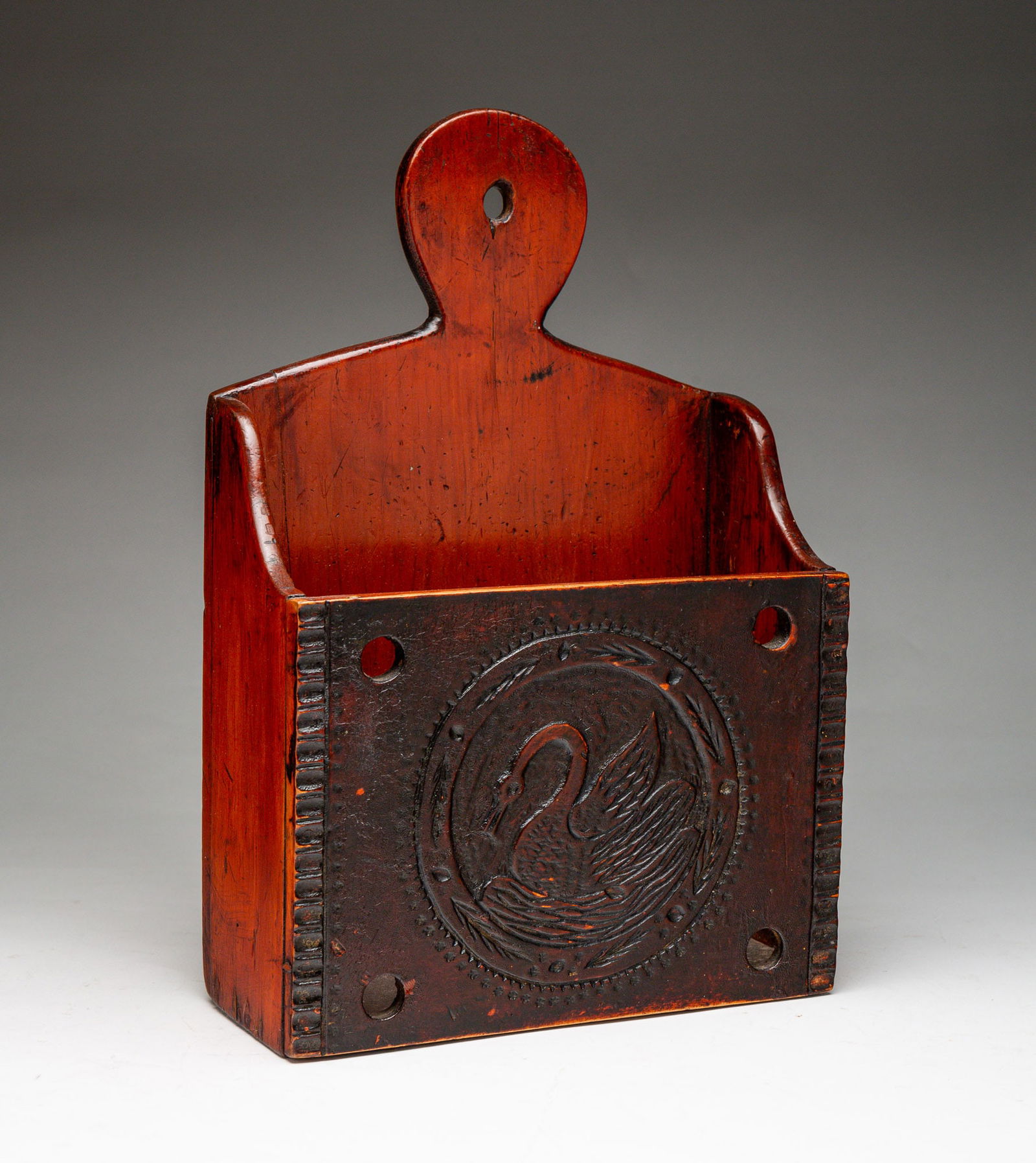 AMERICAN FOLK ART CARVED PINE WALL POCKET WITH SWAN. 12"h. 8"w. 3.75"d.: Second half 19th Century. Lollypop crest, shaped ends, front with chip carved border and center reserved with carved swan.SHIPPING: All purchases from Amelia Jeffers, Auctioneers & Appraisers may be p