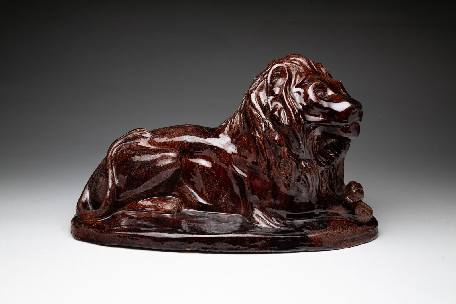AKRON, OHIO GLAZED RED CLAY RECUMBENT LION. 10"h. 17"w. 9"d. (1 of 3)