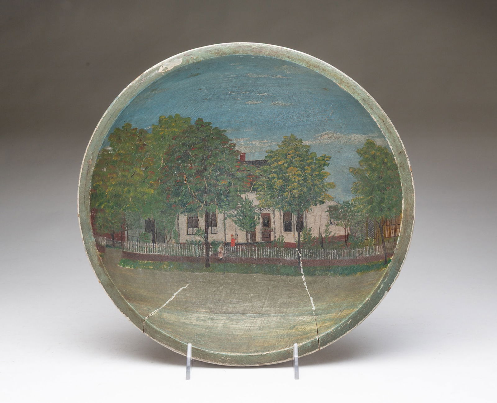 AMERICAN FOLK ART PAINT-DECORATED AND TURNED PINE BOWL WITH STREET SCENE. 3"h. 11.75"d.: Second half 19th Century. Interior scene with Victorian house shaded by trees surrounded by a picket fence. Neighboring houses on either side.SHIPPING: All purchases from Amelia Jeffers, Auctioneers &