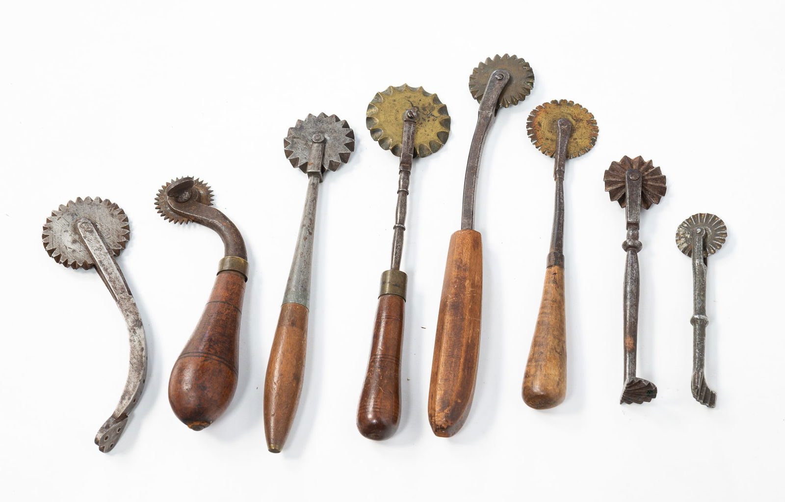 EIGHT AMERICAN PIE CRIMPERS. From 8.35"h. to 4.25"h.: Mid-19th Century. Polished steel, forged iron, some with brass wheels, some with wood handles, and one with heart finial.SHIPPING: All purchases from Amelia Jeffers, Auctioneers & Appraisers may be pi