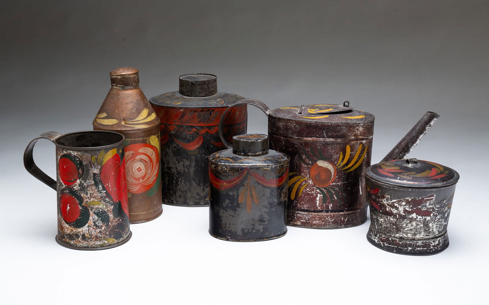 SIX PENNSYLVANIA TOLE ITEMS. Largest, 5.5"h. 10"w.: American, Mid-19th Century. All six have original paint and decoration. Oval teapot with hinged lid, strap handle, straight spout, and green, yellow, red, and white floral and foliate decoration, two