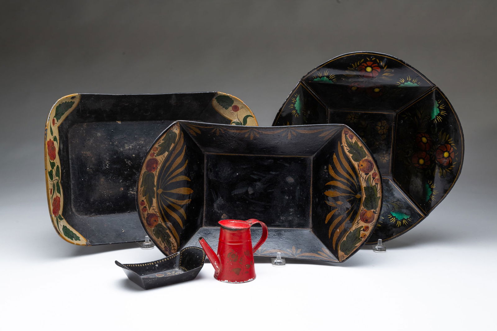 COLLECTION OF PENNSYLVANIA TOLE ITEMS. Largest apple bowl, 2.5"h. 13.5"w. Document box, 6"h. 9.25"w.: American, 19th Century. A red miniature coffee pot in red with gold stenciling, a miniature apple bowl with black paint and floral decoration, two black apple bowls with multicolored floral
