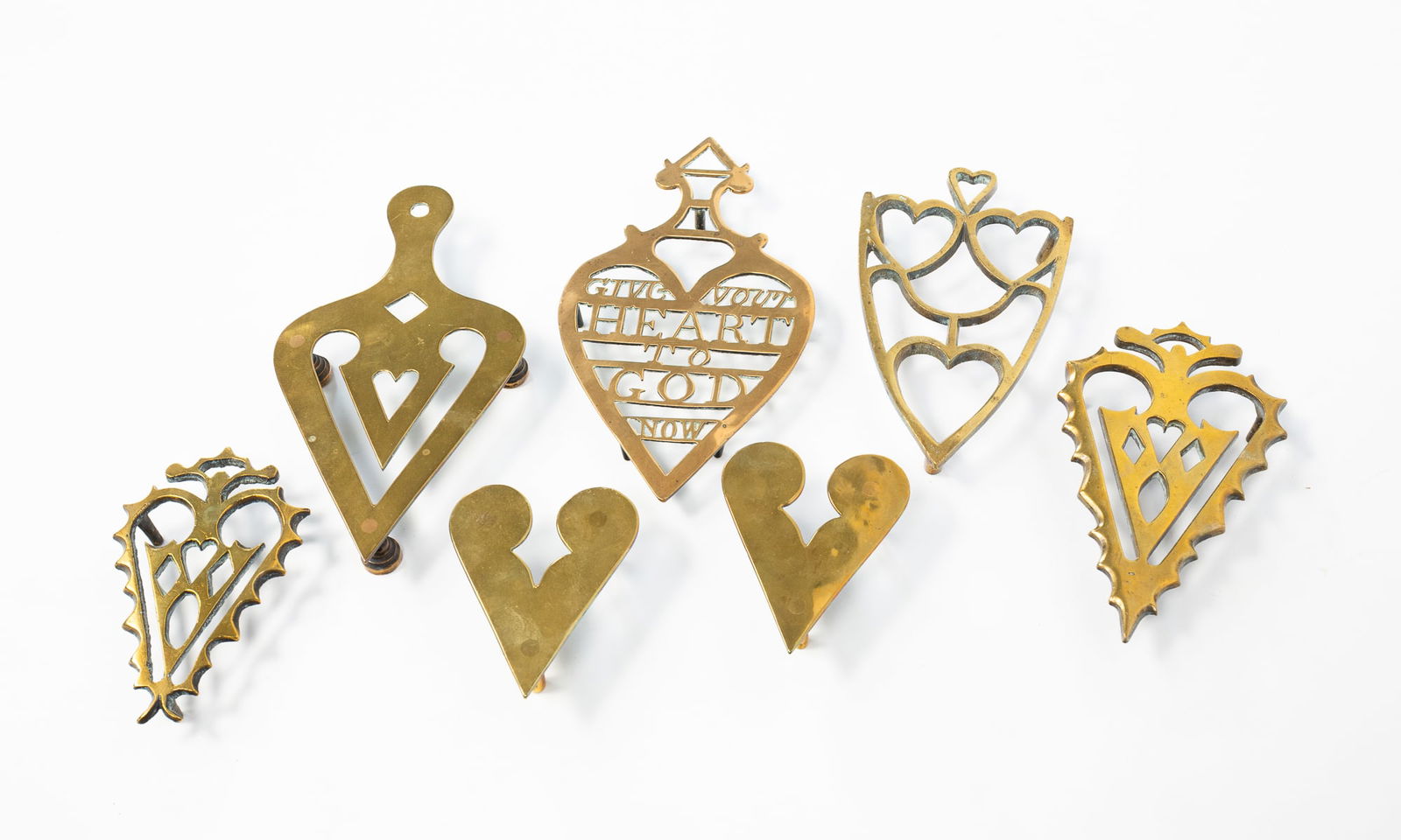 COLLECTION OF BRASS HEART-SHAPED TRIVETS AND DECORATIVE SHOES. Largest, 9.25"h. 5"w. (1 of 6)