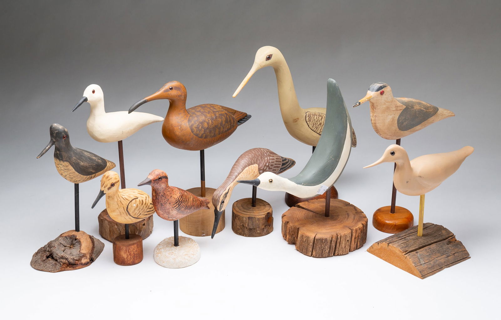 TEN CARVED AND PAINTED SHOREBIRD DECOYS. Largest, 13.5"h.: American, 20th Century. Most with tree slice bases and glass eyes. Seven signed Bob Lee and three are unsigned. In various colors and poses.Provenance: The Lifetime Collection of Ron & the late Betty
