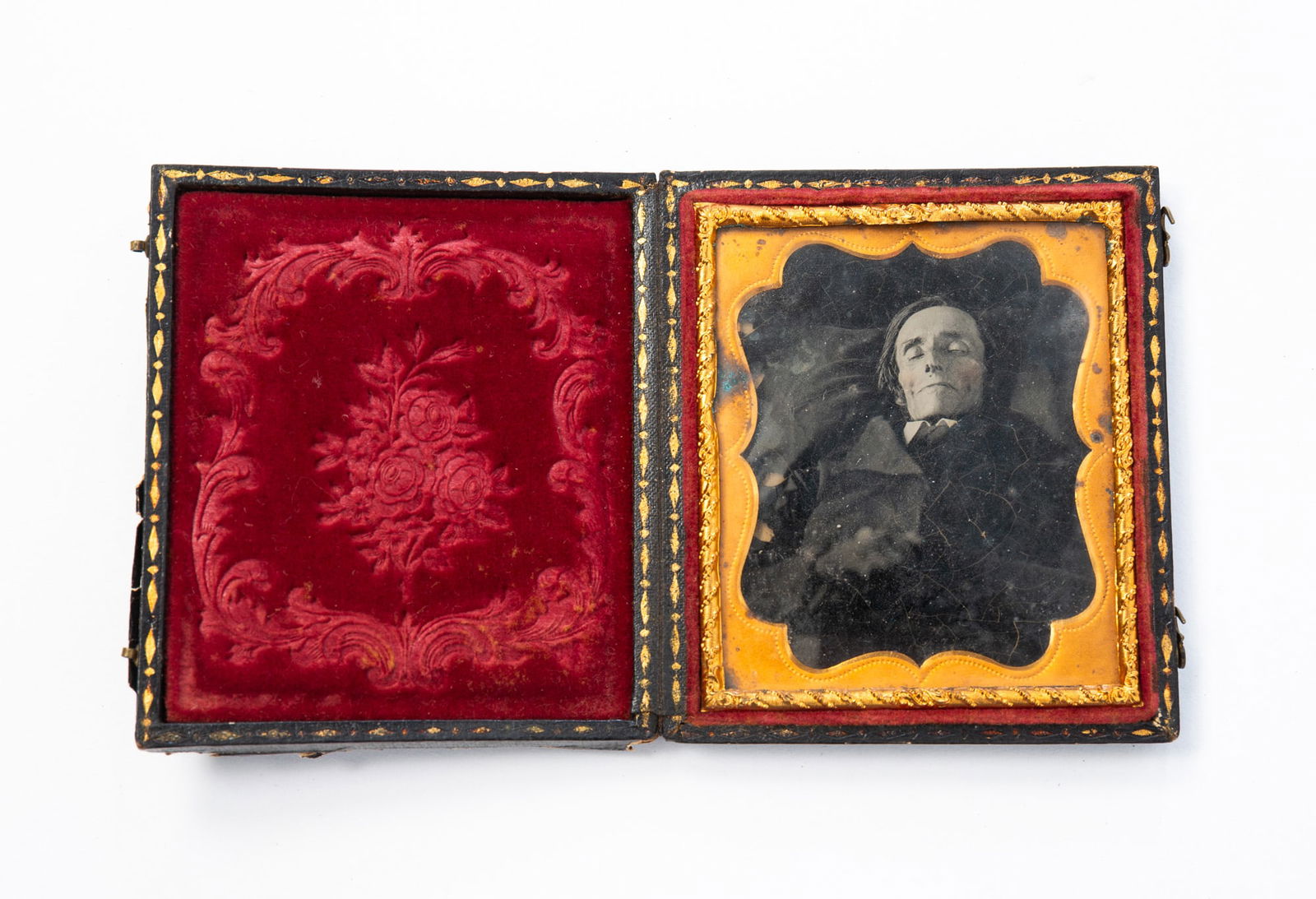 AMERICAN SIXTH PLATE CASED AMBROTYPE POST MORTEM. 3.5"h.: Third quarter 19th Century. A gentleman laid out in a black suit on a black bier.SHIPPING: All purchases from Amelia Jeffers, Auctioneers & Appraisers may be picked up by you or your designated agent