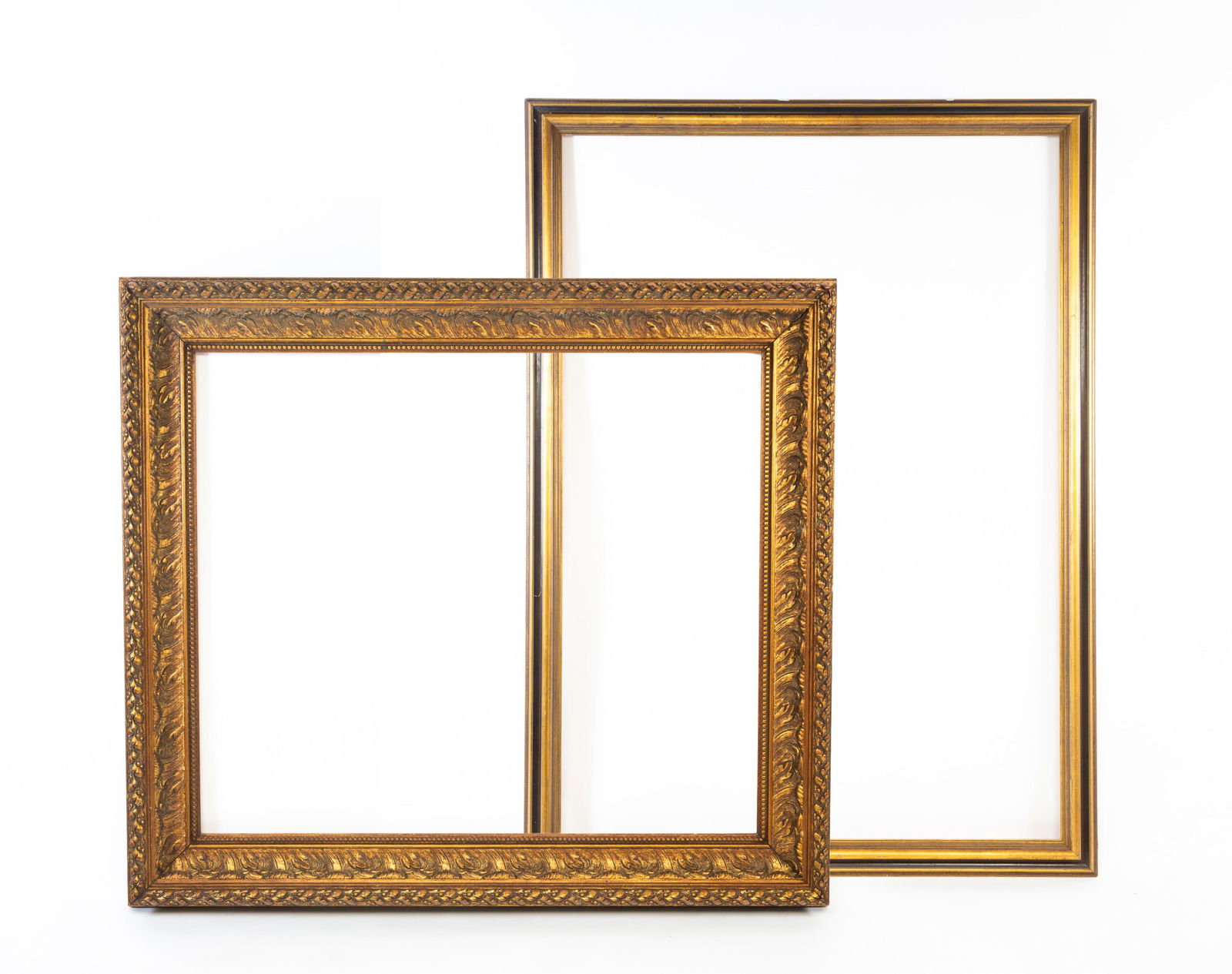 LARGE NEOCLASSICAL STYLE GILTWOOD AND COMPOSITION PICTURE FRAME AND A LARGE MOLDED WOOD AND: American, Early-mid 20th Century. The first having egg-and-dart decoration at back edge, acanthus leaves in cove, and beaded inner edge. 46.5"h. 52.5"w. The second having a scooped inner cove and a th