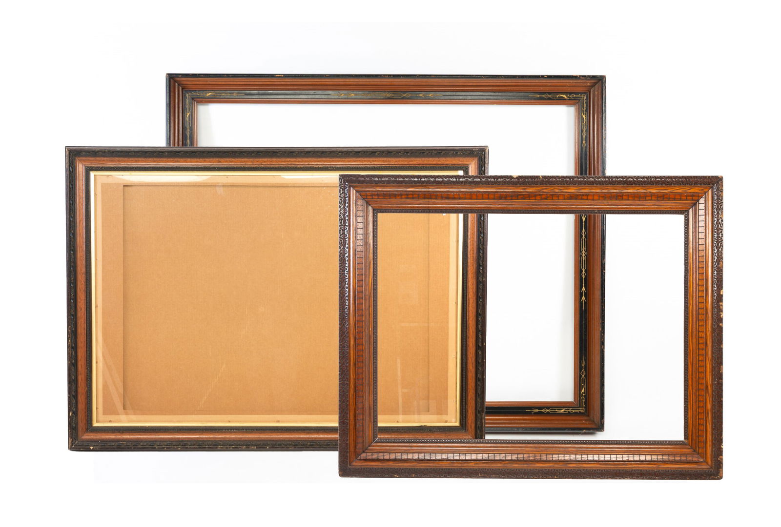 LARGE VICTORIAN WALNUT, EBONIZED, AND GILT-INCISED PICTURE FRAME AND TWO LARGE CARVED OAK AND: American. The first ca. 1900, molded walnut with ebonized and decorative incised gilt accents. 43.5"h. 53.5"w. The second early to mid-20th century, having a stylized floral and vine outer and inner b