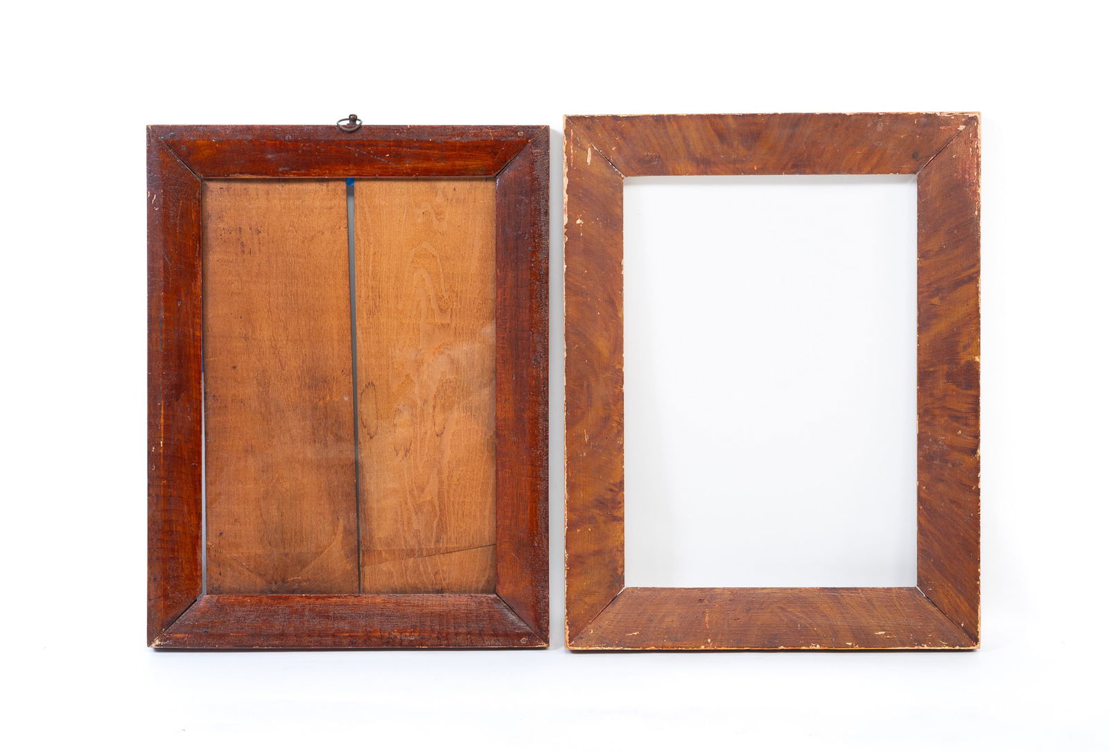 TWO GRAIN-PAINTED WOOD PICTURE FRAMES. The larger, 18.5"h. 13.5"w.: American, 19th Century. The first painted to look like tiger maple with alligatored varnish, beveled profile, lap joints, square nails, a brass ring hanger on top, glass, and pine backing boards. Rabb