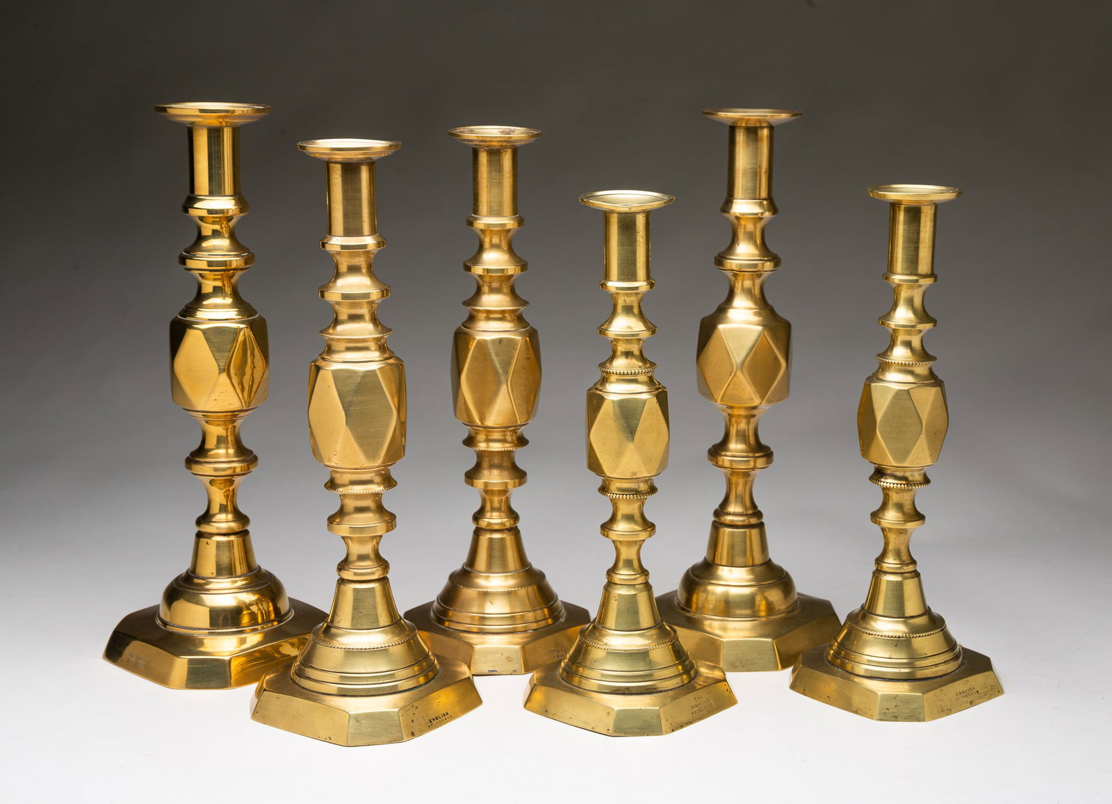 SIX ENGLISH BRASS CANDLESTICKS.: Second half 19th Century. A pair of "The Diamond Princess", 10.75"h. A pair of "The Diamond Prince", 11.75"h. A single "King Diamonds", 12.5"h. And a single in the same pattern, 11.75"h.