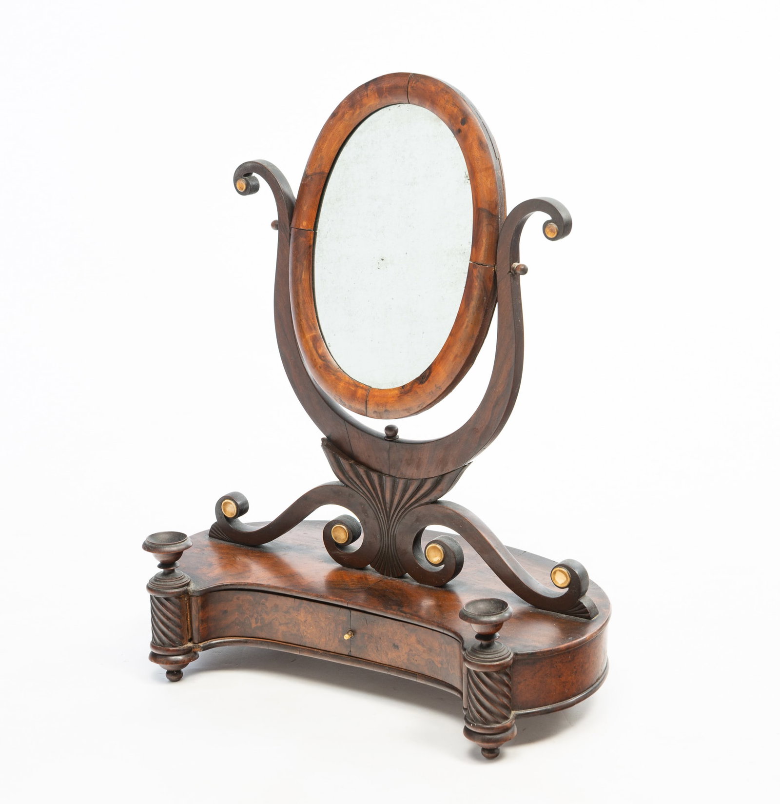 REGENCY MAHOGANY TABLETOP SHAVING MIRROR.: English, Early 19th Century. Mahogany and burl veneer. Oval mirror, scrolled supports, single drawer with concave front, turned columns, bone accents, and bun feet. 23"h. 17.5"w. 10"d.