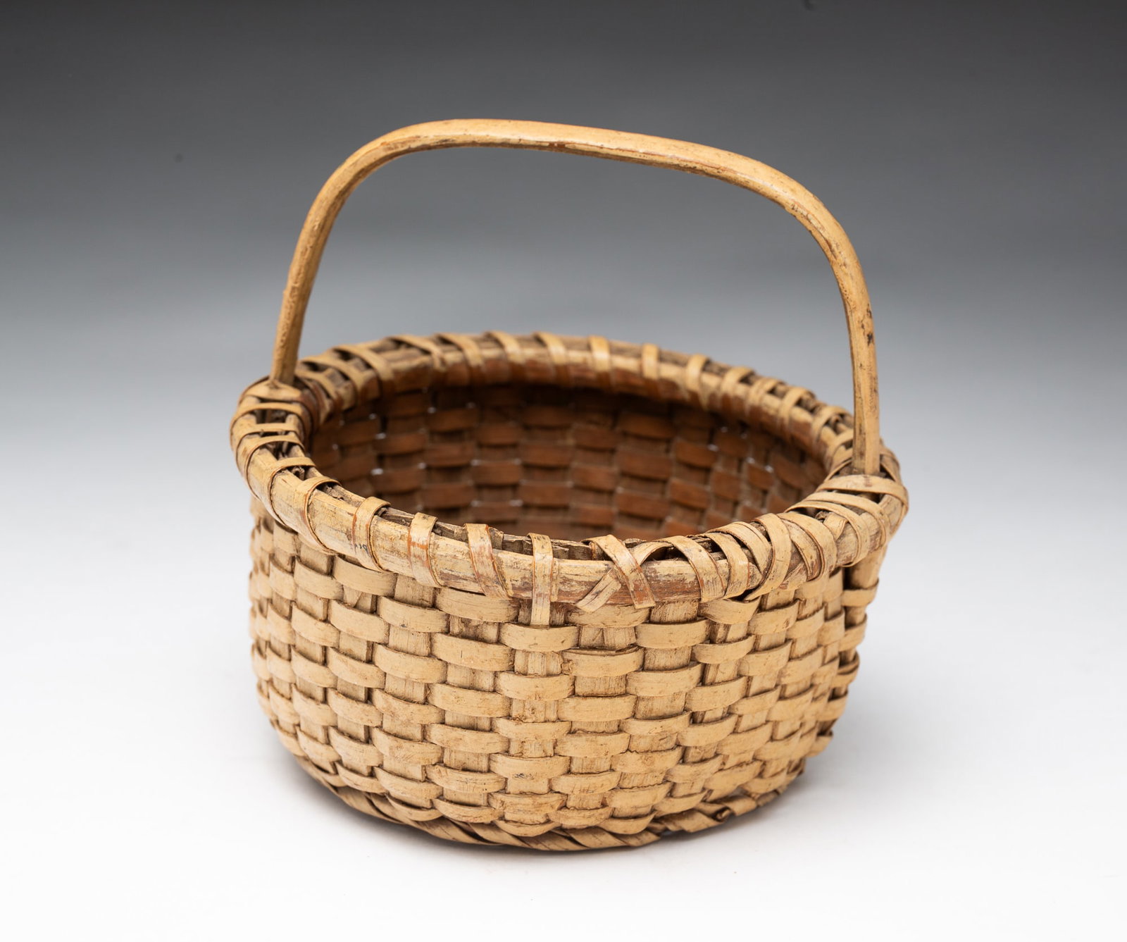 DIMINUTIVE AMERICAN CREAM-PAINTED SPLINT-WOVEN BASKET. (1 of 3)