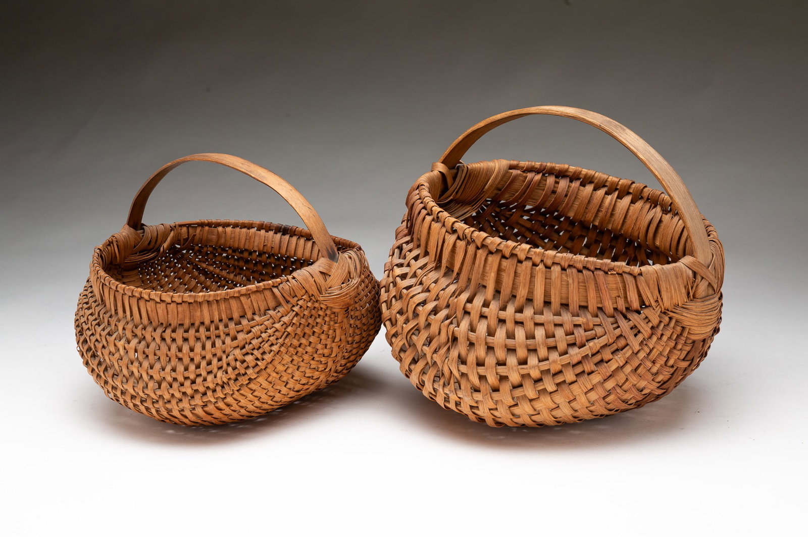 TWO AMERICAN SPLINT-WOVEN BASKETS WITH BENTWOOD HANDLES. (1 of 4)
