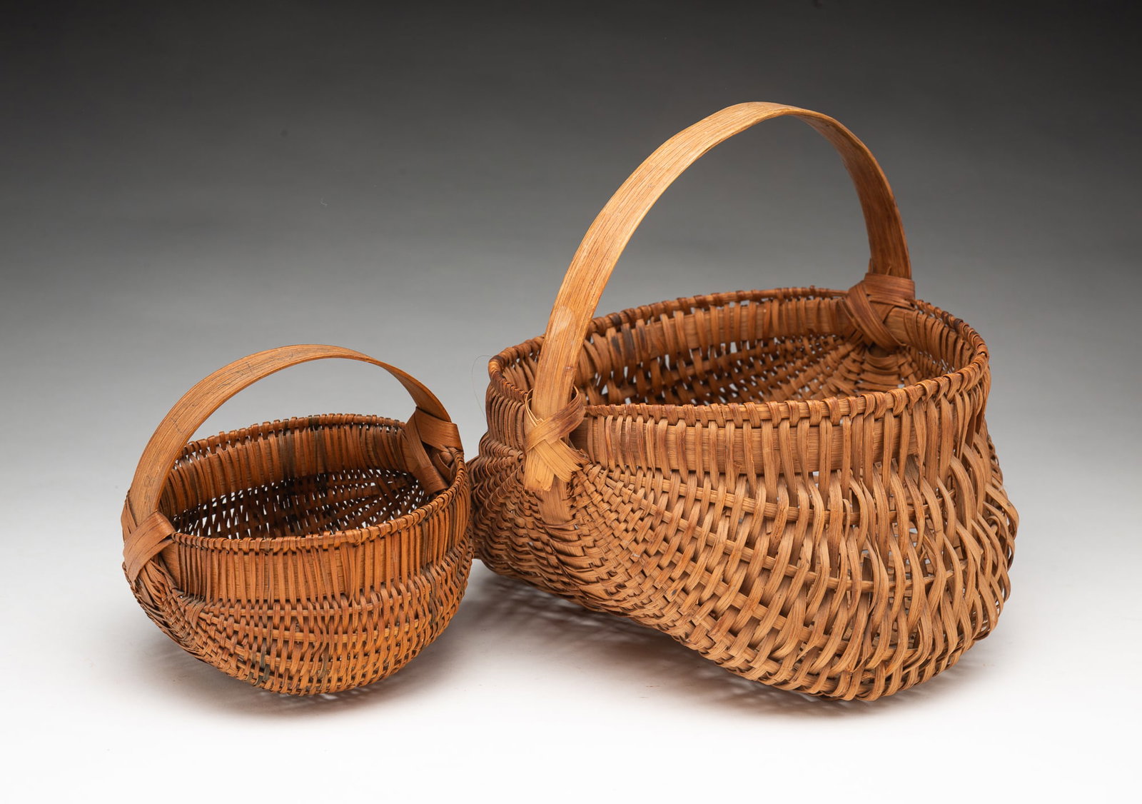 TWO DIMINUTIVE AMERICAN SPLINT-WOVEN BUTTOCKS BASKETS. (1 of 4)