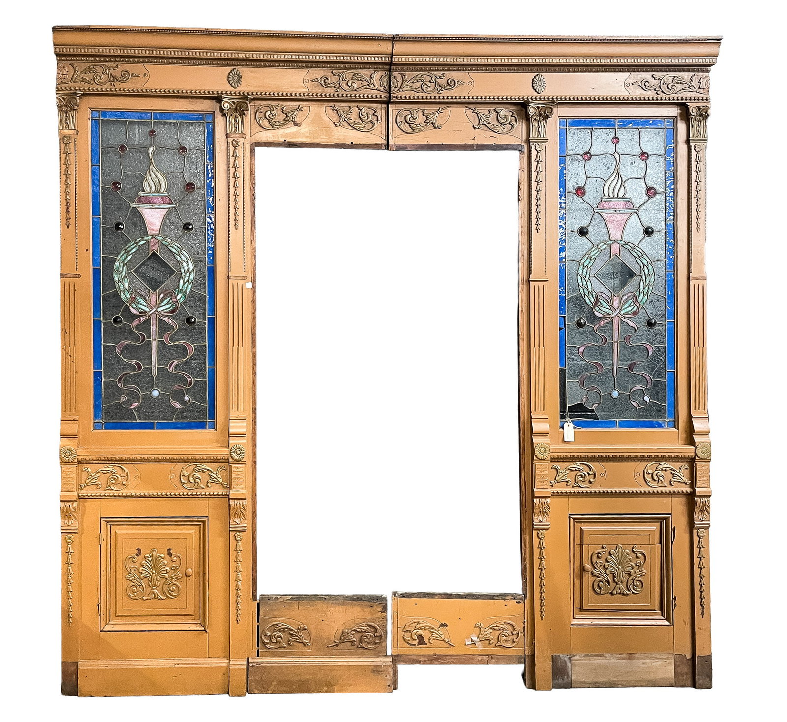 AMERICAN ARCHITECTURAL APOTHECARY PARTITION WITH LEADED COLORED GLASS WINDOWS.: Ca. 1900. Mahogany. Molded cornice, lower dentil and egg courses, frieze with applied foliate scroll works, flat stopfluted pilasters, composite style capitals, acanthus carvings and applied bell flow