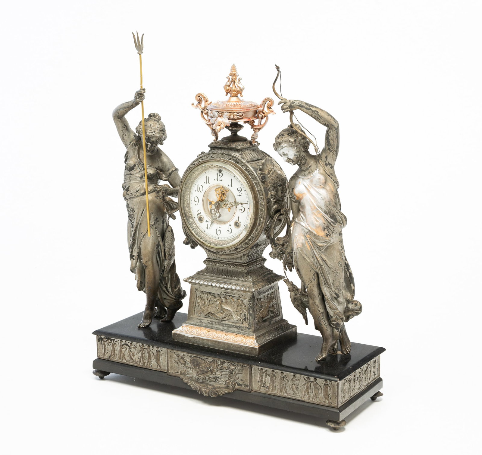 ANSONIA CLOCK CO. FIGURAL MANTEL CLOCK.: ANSONIA CLOCK CO. FIGURAL MANTEL CLOCK. American, Late 19th Century. White metal. Two robed huntresses flanking a round clock case on a monument plinth, base with black enamel top, embossed Greek figu