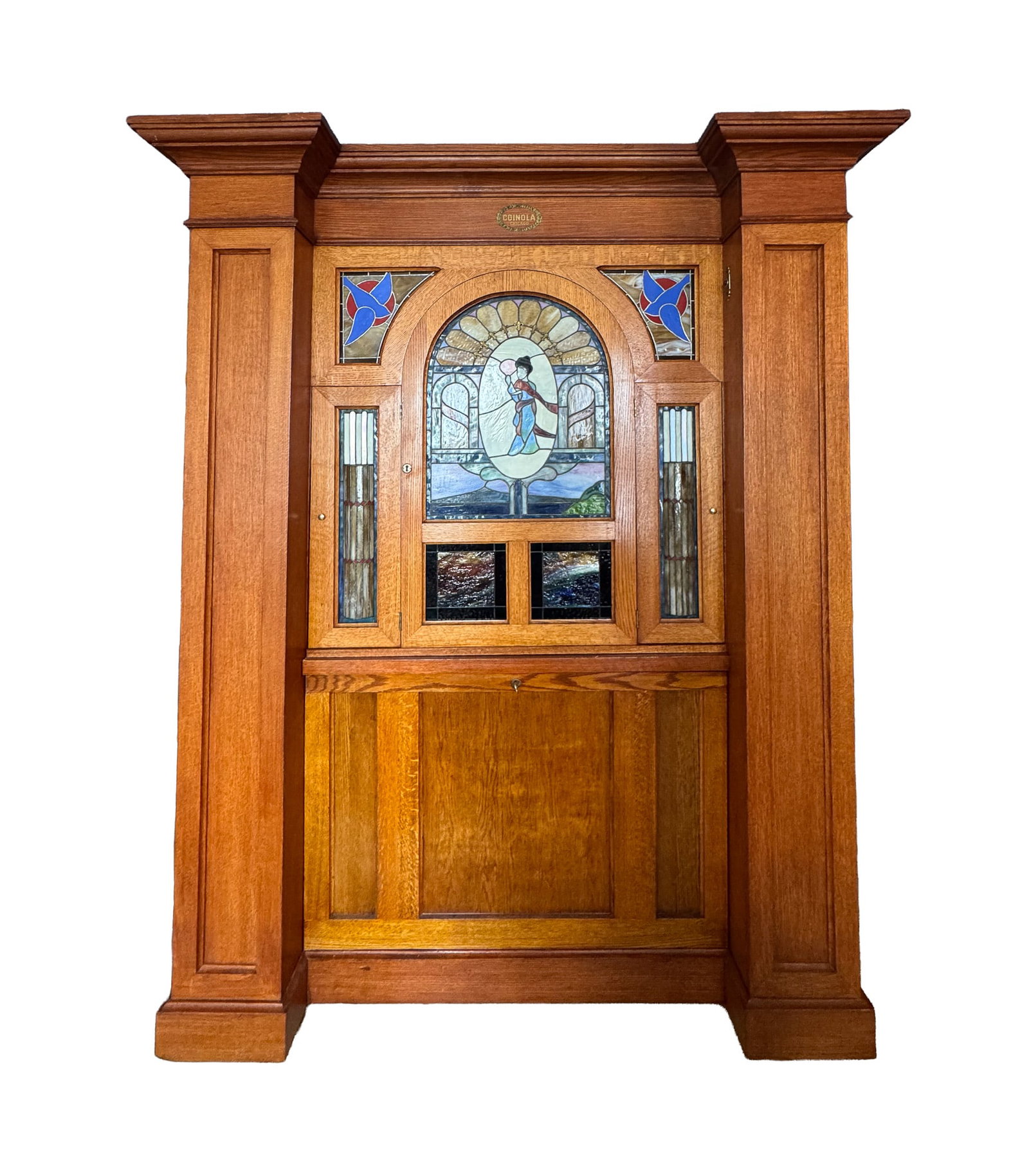 COINOLA COIN-OPERATED ORCHESTRION.: American (Chicago Illinois), Early 20th Century. Quarter-sawn oak cabinet, marked Coinola, Chicago, with stained and leaded glass front panels. Coin-operated orchestrion with visible paper roll mechan