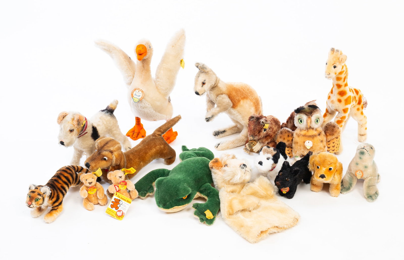 ASSORTED STEIFF MOHAIR STUFFED ANIMALS.: Germany and Austria, Early-mid 20th Century. Sixteen animals, most still with ear tags. Includes bears, dogs, a seal, tiger, squirrel, kangaroo, duck, frog, and a giraffe. Overall, 7"h. 14"w.