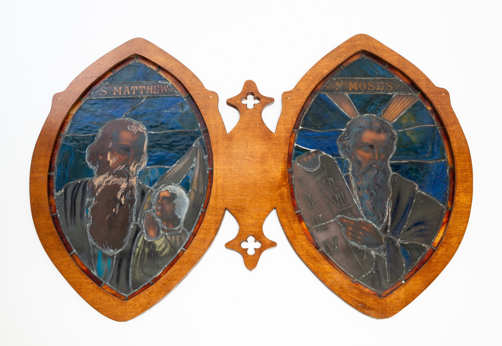 TWO AMERICAN STAINED AND LEADED GLASS CHURCH WINDOWS.: TWO AMERICAN STAINED AND LEADED GLASS CHURCH WINDOWS. Second half 19th Century. In a common plywood frame. Amber border, blue slag background and stained glass "Saint Matthew" and "Prophet Moses". 39"