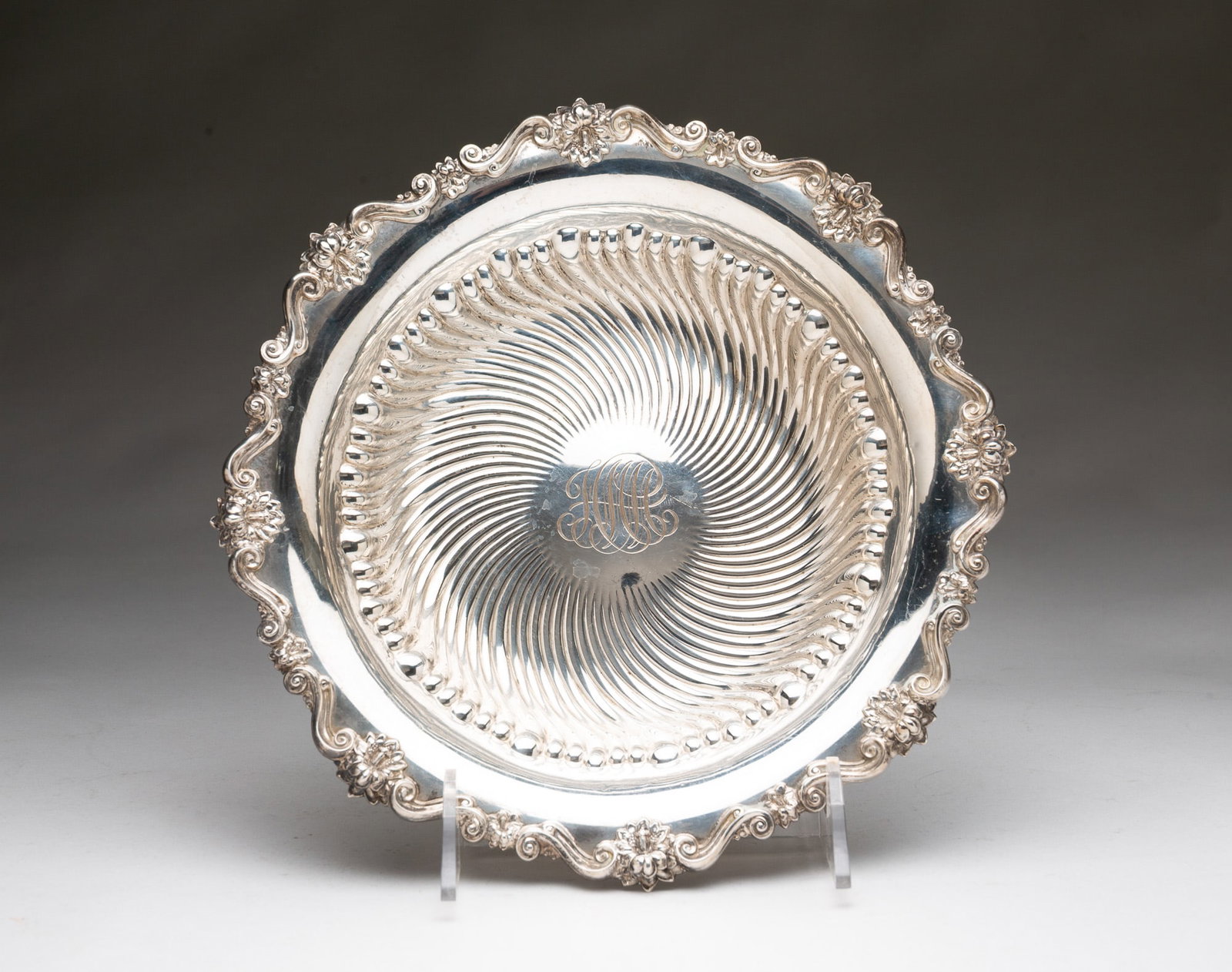 MERIDIAN STERLING SILVER HOLLOWARE BOWL WITH FLORAL EDGE.: American (Connecticut), 20th Century. Round bowl with floral edge, shaped bowl, and monogram to center. Hallmarked to bottom. 2"h. 10.25"d. Approximately 9.2 ozt.**Note: Bidders who are not yet