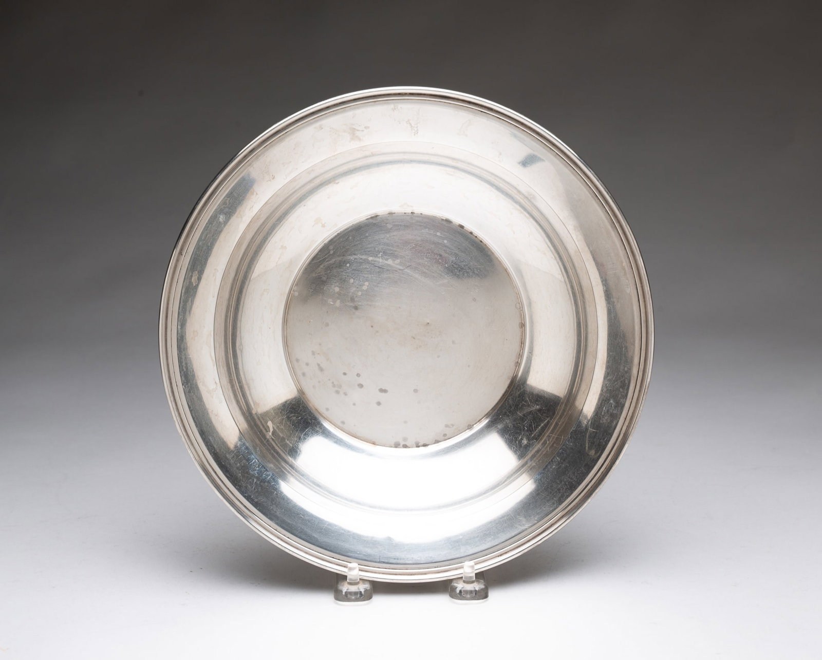 AMERICAN STERLING SILVER HOLLOWWARE BOWL.: 20th Century. Bowl with simple form and stepped edge. 1.75"h. 9.5"w. Approximately 6.6 ozt.**Note: Bidders who are not yet established with our firm will be required to pay for jewelry, coins, and