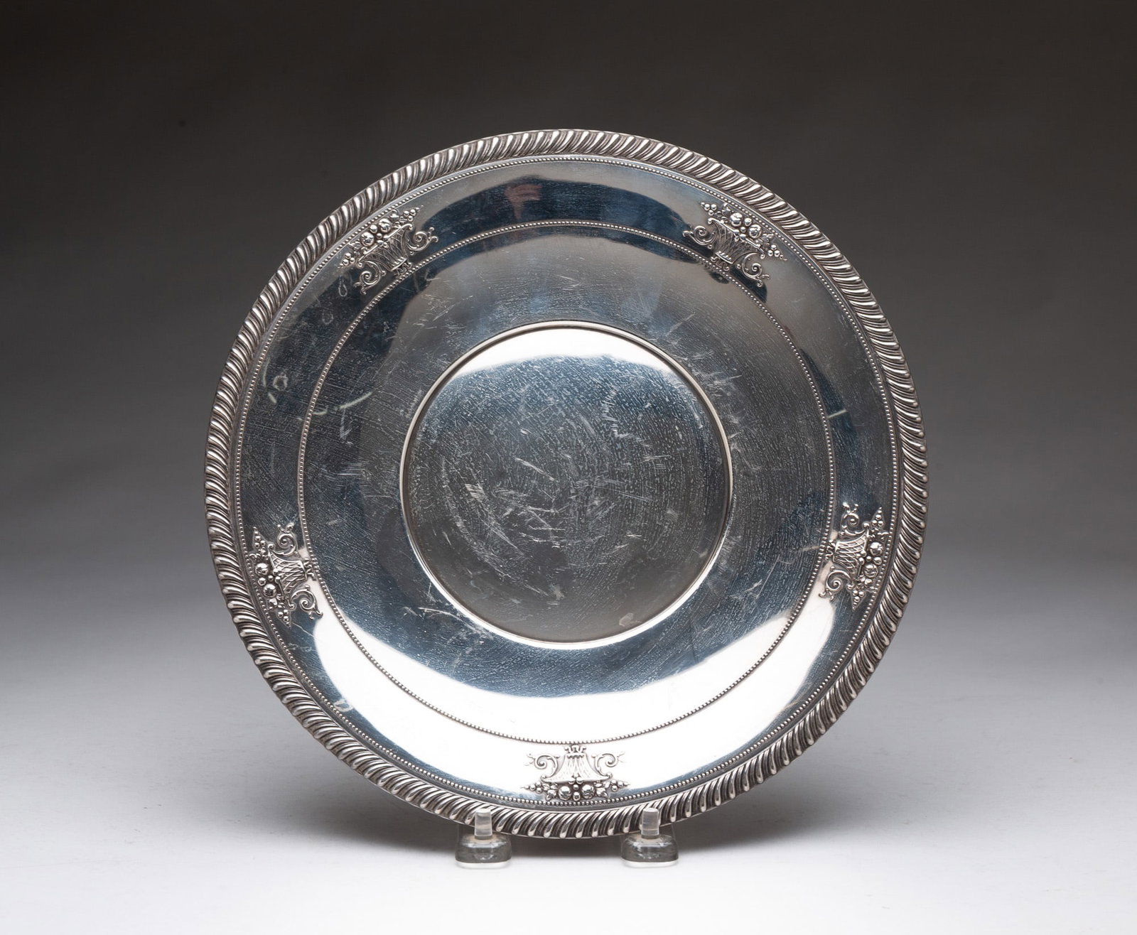 M. FRED HIRSCH STERLING SILVER TRAY WITH FRUIT BASKET DECORATION.: American (New Jersey), 20th Century. Round tray with raised fruit basket decoration. Hallmarks to back. 10"d. Approximately 8.6 ozt.**Note: Bidders who are not yet established with our firm will be re