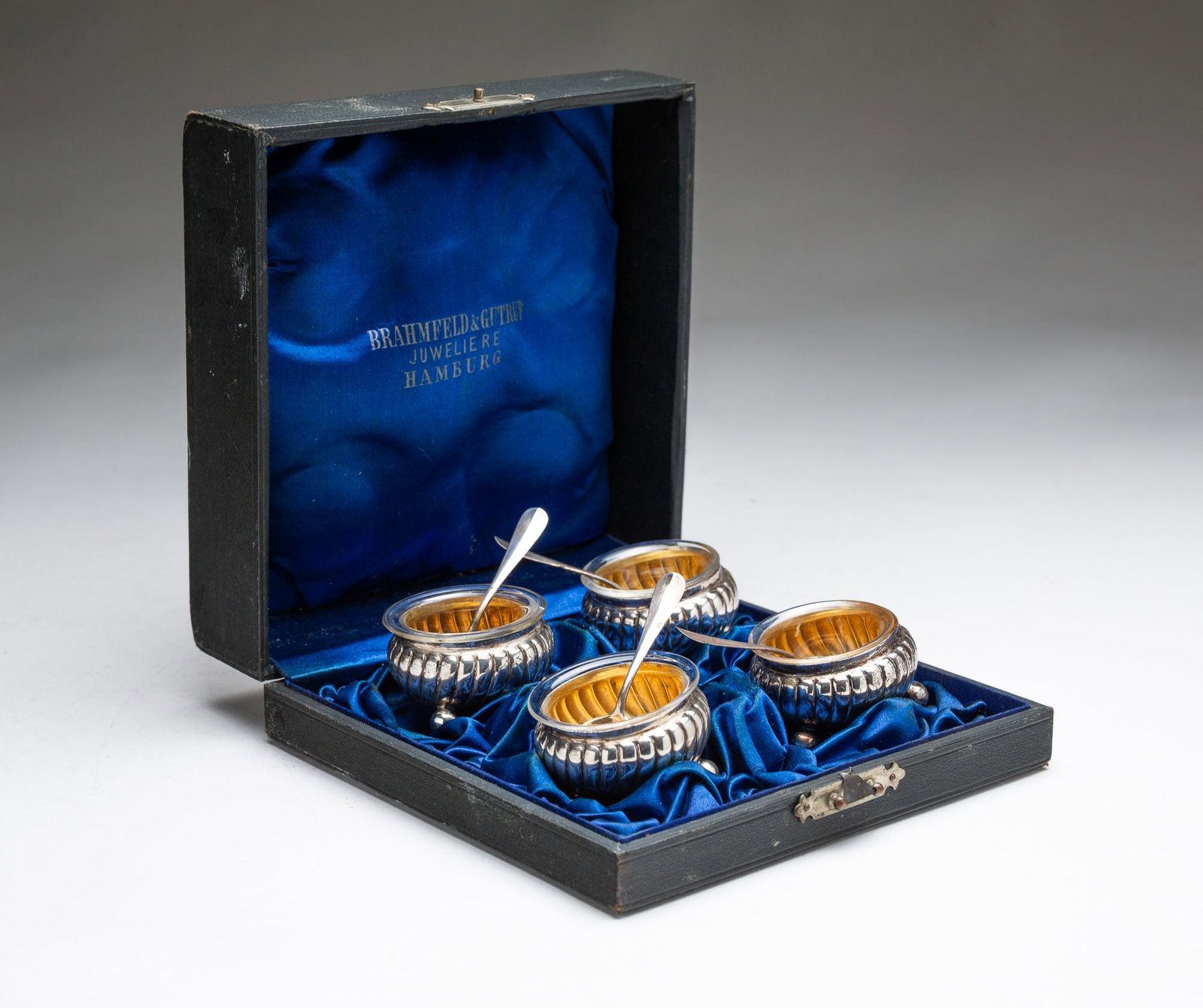 FOUR EUROPEAN 800 SILVER OPEN SALTS WITH SPOONS IN FITTED CASE.: European, 20th Century. Four footed open salts with ribbed bodies, glass inserts, and four spoons. All housed in a lined case. 2.25"h. 6.3"w. Approximately 4.3 ozt.**Note: Bidders who are not yet
