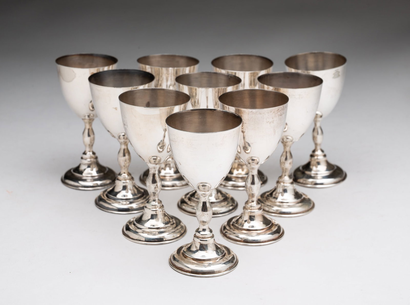 TEN MEXICAN STERLING SILVER CORDIALS.: TEN MEXICAN STERLING SILVER CORDIALS. 20th Century. Stepped bottoms, shaped stems, and plain cups. 3.5"h. Approximately 14 ozt. **Note: Bidders who are not yet established with our firm will be requir