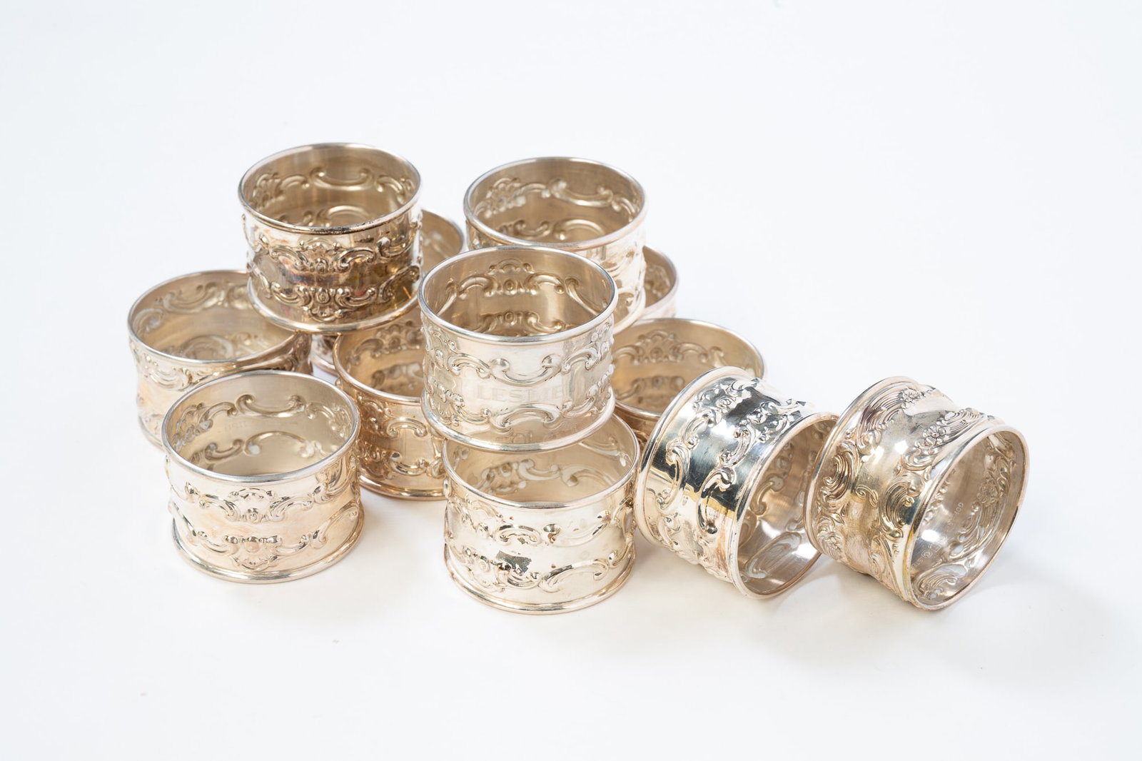 TWELVE GORHAM STERLING SILVER NAPKIN RINGS.: American, 20th Century. Round napkin rings with a foliate pattern and monogrammed. All hallmarked to interior. 1.15"h. 1.75"d. Approximately 8.2 ozt.**Note: Bidders who are not yet established with