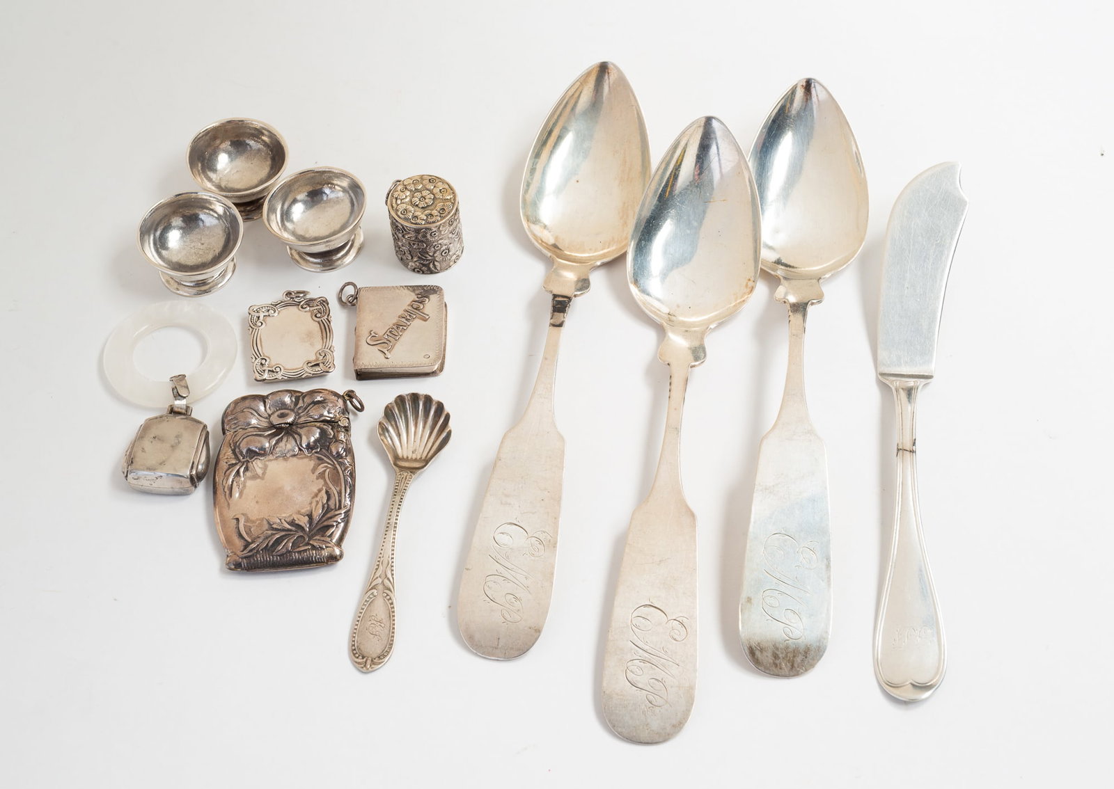 GROUP OF AMERICAN SILVER ACCESSORIES.: Ca. 1900. Including two stamp holders, a matchsafe, a baby rattle, a coin silver shell spoon, three coin silver footed individual salts, three C. Allen & Co. serving spoons, a vinegarette, and a