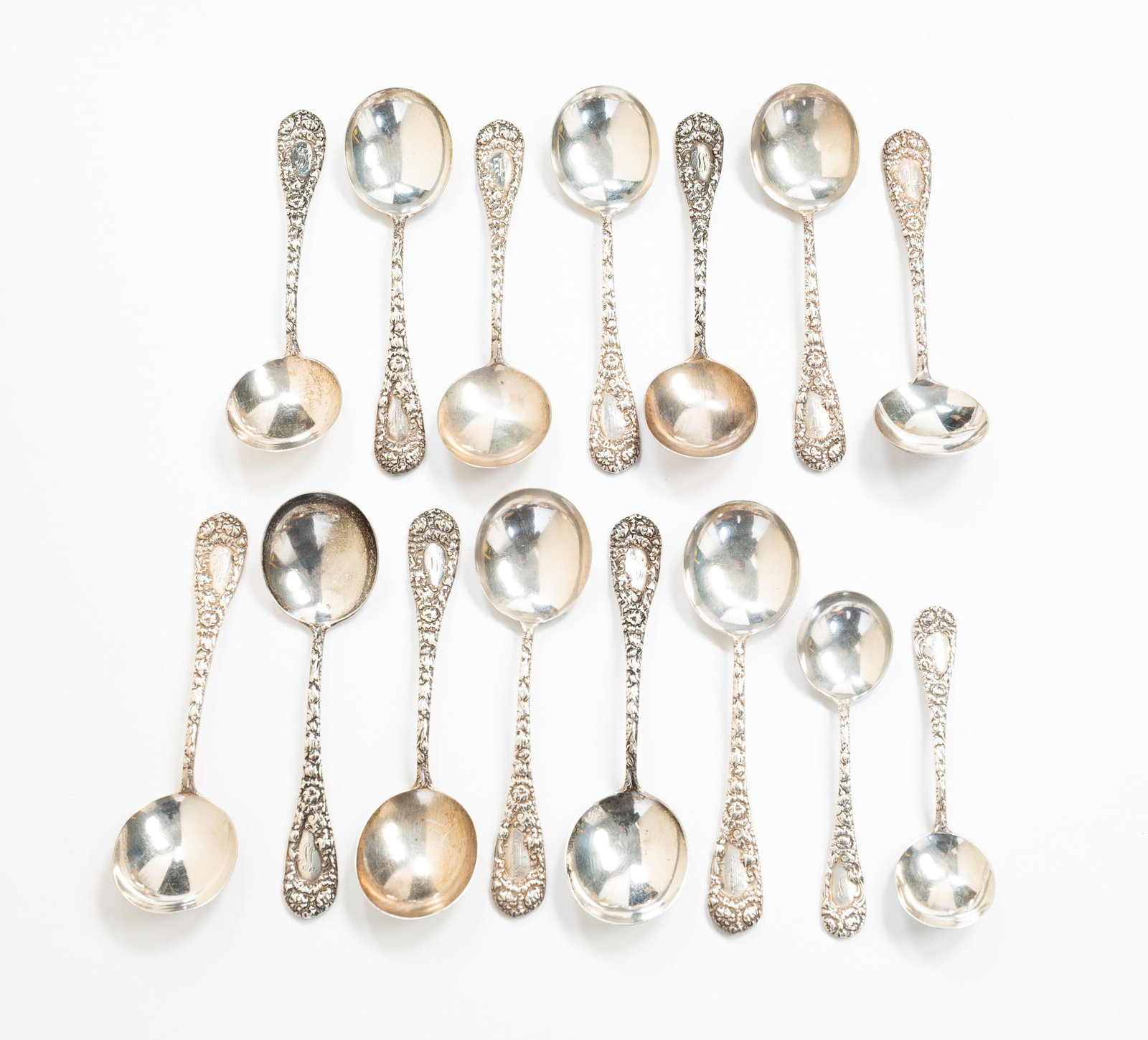 FIFTEEN DURGIN "CHRYSANTHEMUM" STERLING SILVER SPOONS.: American, pat. 1893. Thirteen cream soup spoons and two bullion spoons. 7"l. Approximately 30.8 ozt.**Note: Bidders who are not yet established with our firm will be required to pay for jewelry,