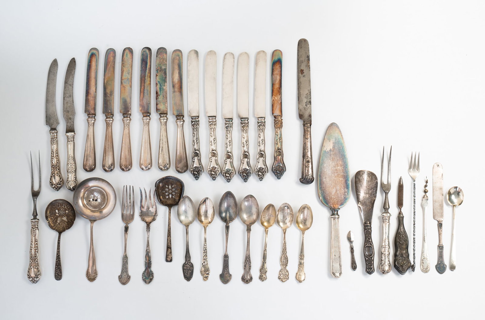 GROUP OF ASSORTED AMERICAN STERLING SILVER FLATWARE.: 20th Century. Including hollow-handled knives, forks, spoons, serving spoons, souvenir spoons, and other utensils. 10.25"l. Approximately 12.8 ozt. excluding hollow handled pieces.**Note: Bidders who