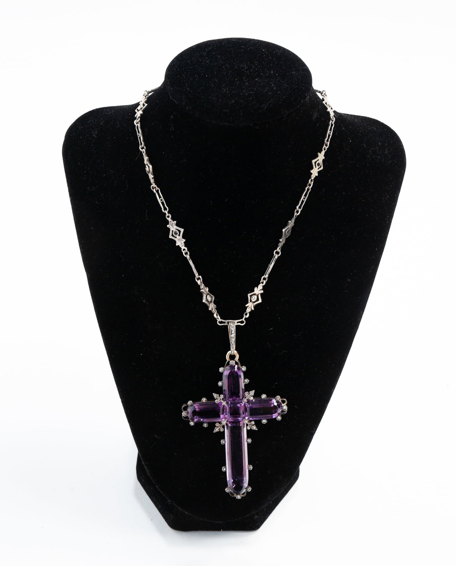 VICTORIAN CROSS PENDANT WITH SILVER CHAIN.: Victorian. Arms of the cross formed by elongated fancy cut purple stone (appears to be glass), square cut stone to center. The border accented with small rose cut diamond collets, bail set with rose