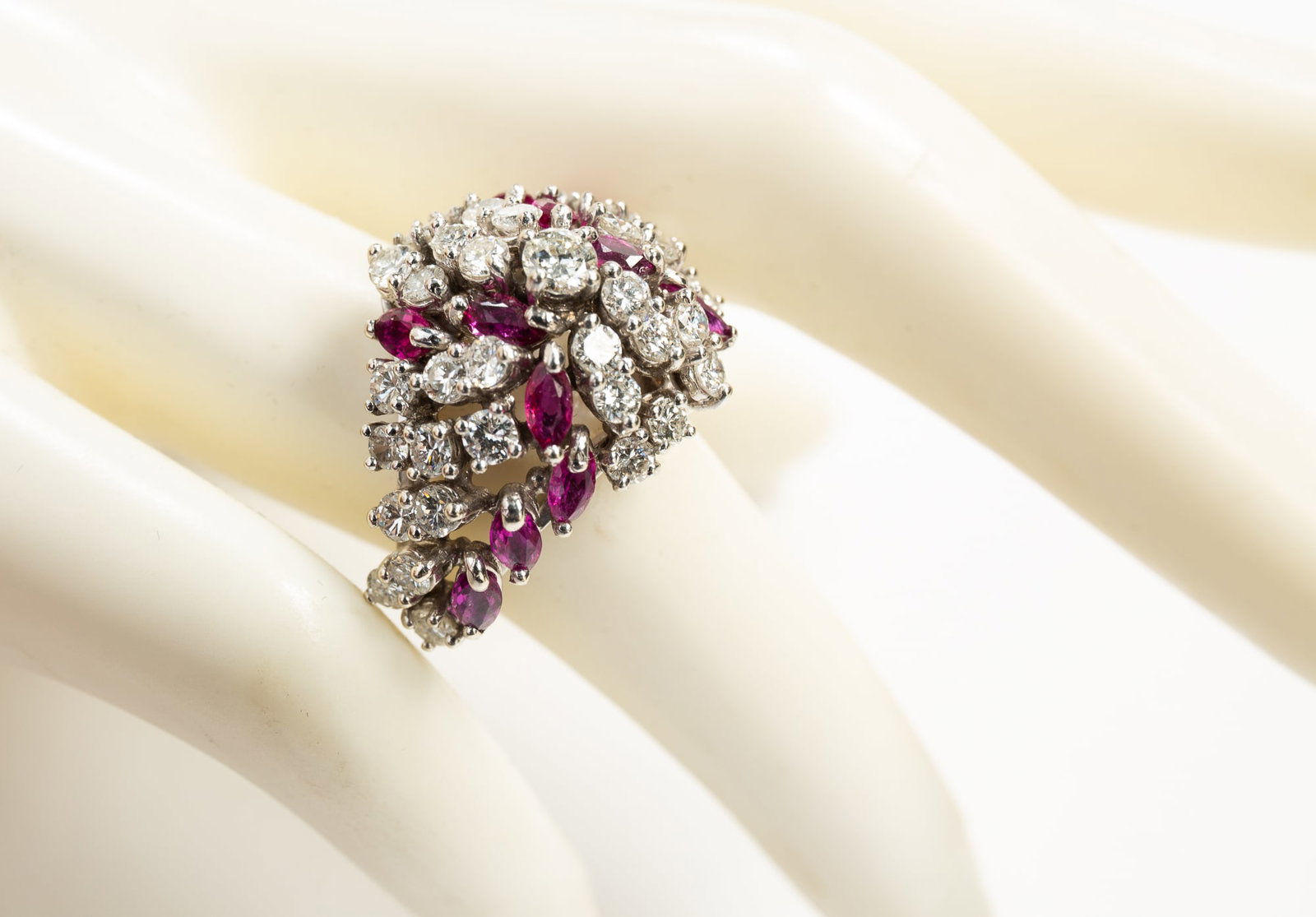 14K WHITE GOLD DIAMOND AND RUBY COCKTAIL RING.: American, 20th century. Stamped 14K white gold dome shaped ring set throughout with thirty-nine round brilliant diamonds and twelve marquise cut rubies, all prong set. Center diamond approx. .20ct., e