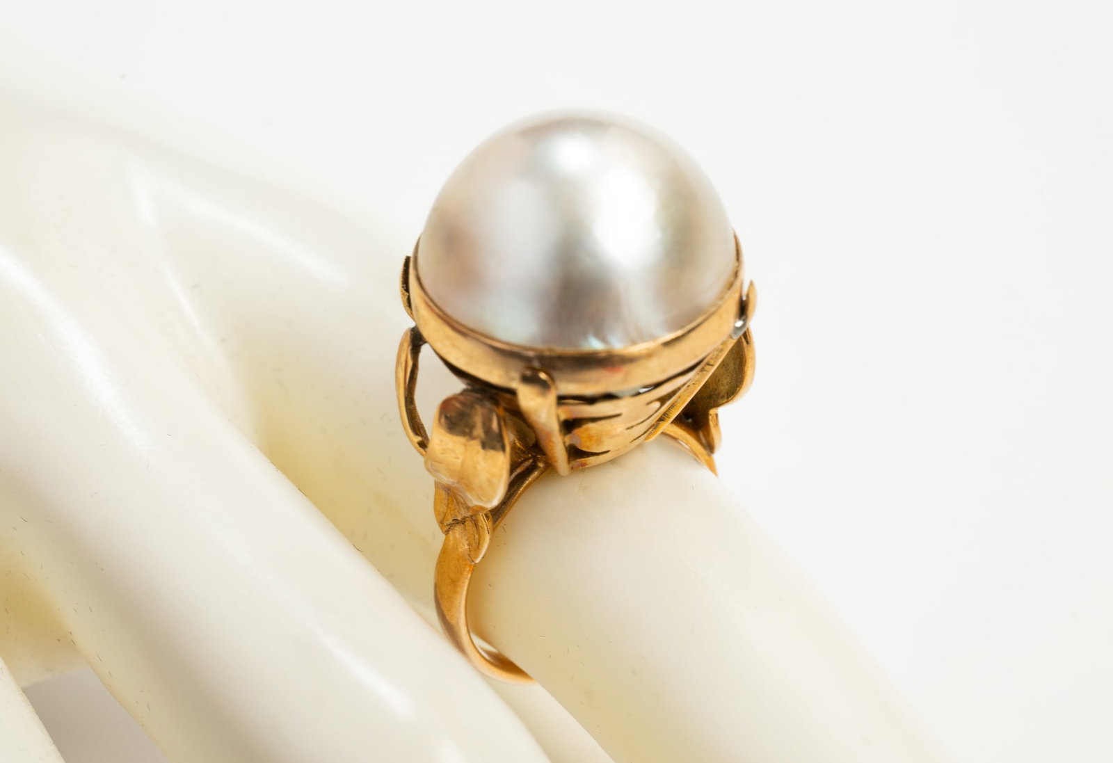18K YELLOW GOLD MABE PEARL RING.: Late 20th century. Stamped 18K ring featuring large mabe pearl, approx. 17.5mm diameter. Tall basket-like mounting with cut out design and stylized shoulders. Overall ring height approx. 1.5", size 7.