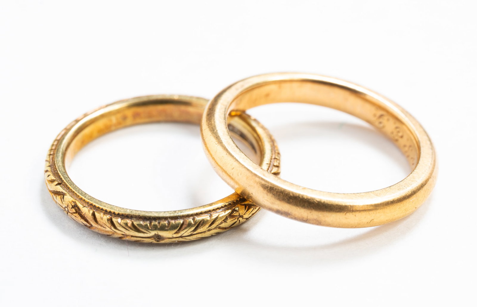TWO 18K YELLOW GOLD BANDS.: Ca. 1900. One simple domed band, hallmarked and engraved "C.A.N. to P.E.F.". size 4.5, and the other with engraved decoration all around, hallmarked and engraved "V.S. to B.J.N. Aug 1939", size 4.25.