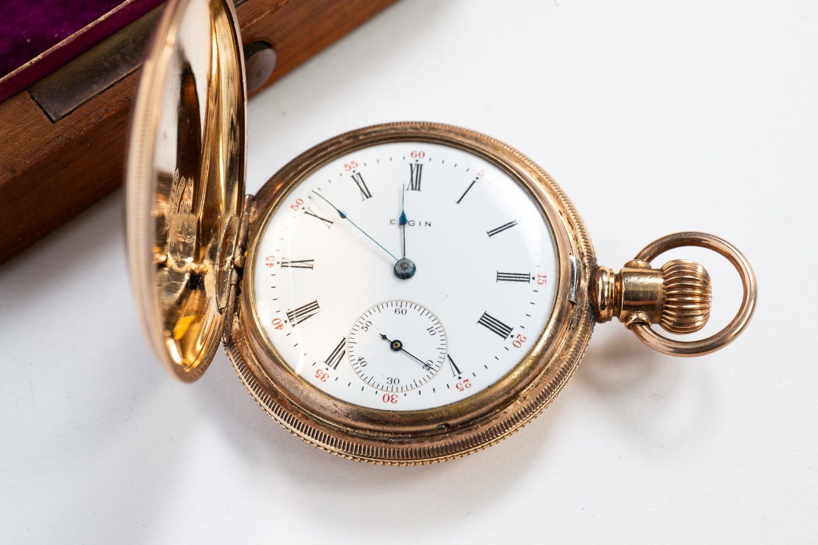 LADIES ELGIN POCKET WATCH IN 14K GOLD PLATED DUEBER CASE.: American, First quarter 20th Century. White porcelain face with black Roman numerals, seconds dial, and housed in a 14k yellow gold Dueber hunters case engraved with floral flourishes, a scenic landsc