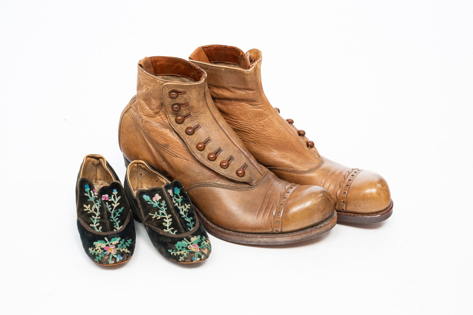 TWO PAIRS OF VICTORIAN SHOES, INCL. "THE CROSSETT" ANKLE BOOTS.: American, 19th Century. A pair of tan button ankle boots, marked "The Crossett $5.00 Shoe" to the bottom, and a pair of children's embroidered velvet loafers. Boots, 6.5"h. 11"d.