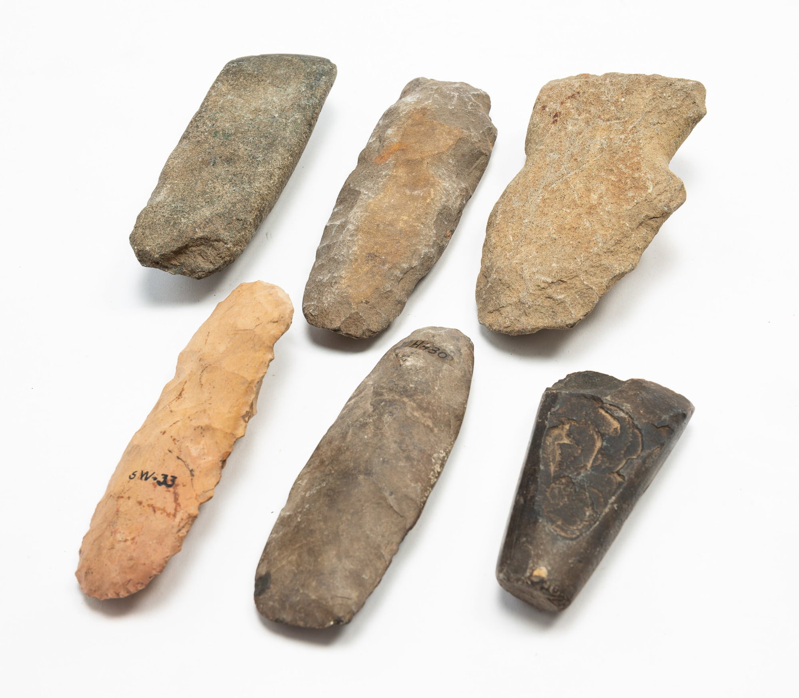 SIX NATIVE AMERICAN STONE TOOLS.: SIX NATIVE AMERICAN STONE TOOLS. Comprising cutting tools, some knapped, with some with inscriptions. Largest, 5.75"l. 3.5"w. Provenance: From the Lifetime Collection of the late Ken Hanna (Chester,