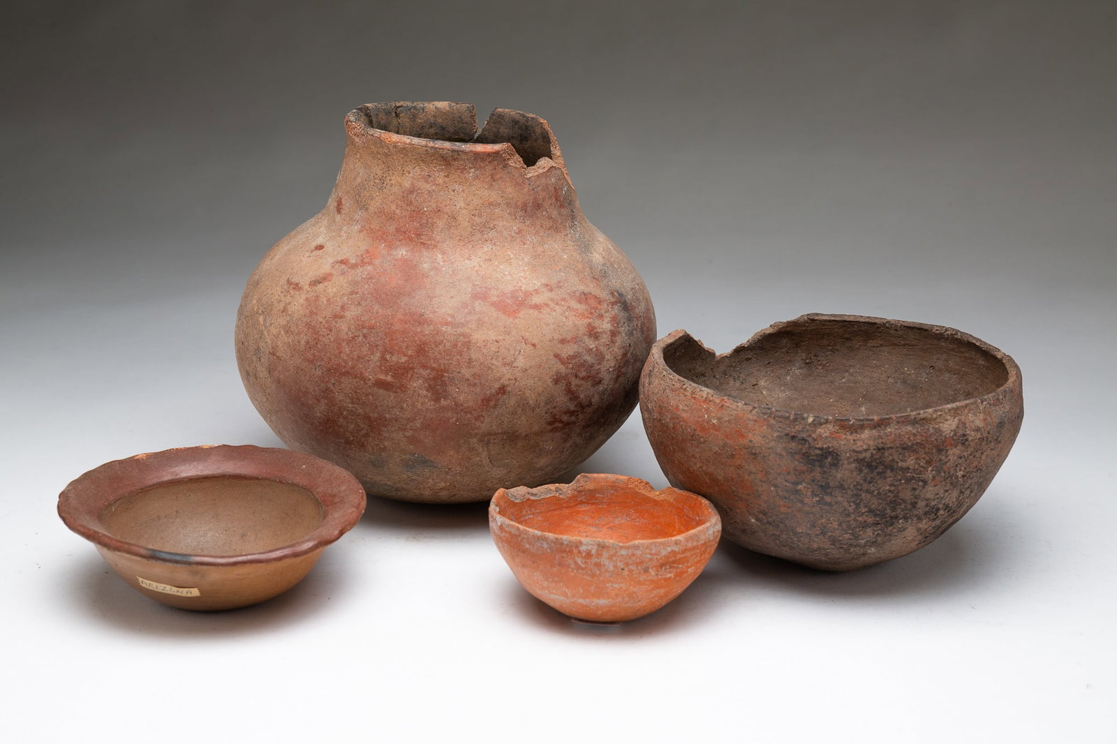 FOUR NATIVE AMERICAN POTTERY VESSELS.: FOUR NATIVE AMERICAN POTTERY VESSELS. Arizona and Southwestern U.S., Late 19th Century. Olla with damaged rim and three bowls, two with damaged rims and the third with a wide red-glazed rim. Olla, ex