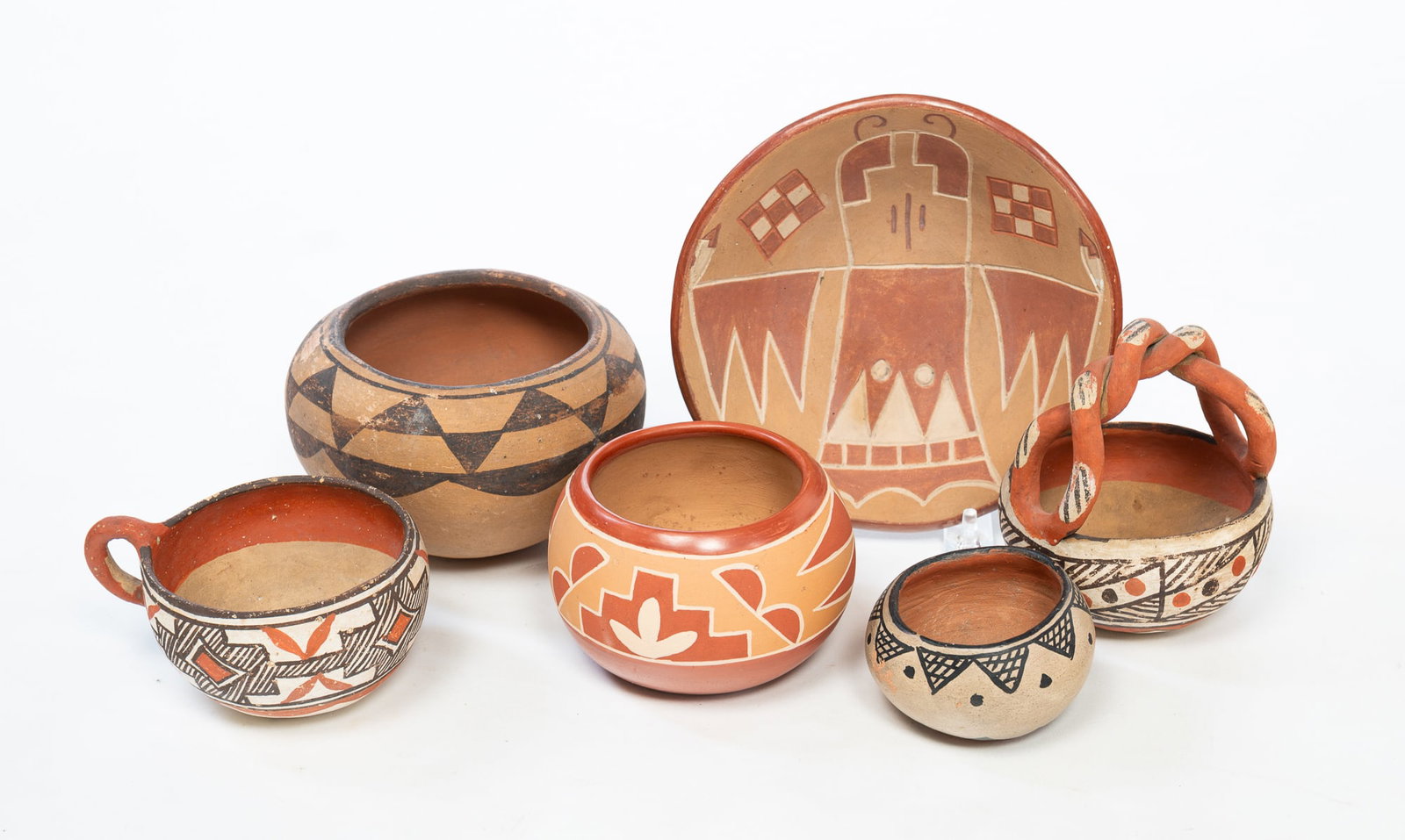 SIX NATIVE AMERICAN PUEBLO POTTERY VESSELS.: SIX NATIVE AMERICAN PUEBLO POTTERY VESSELS. Acoma, Isleta, Cochiti, and San Juan, 20th Century. Includes a twisted handle bowl, two pots with black painted decoration, a cup with black and red painted
